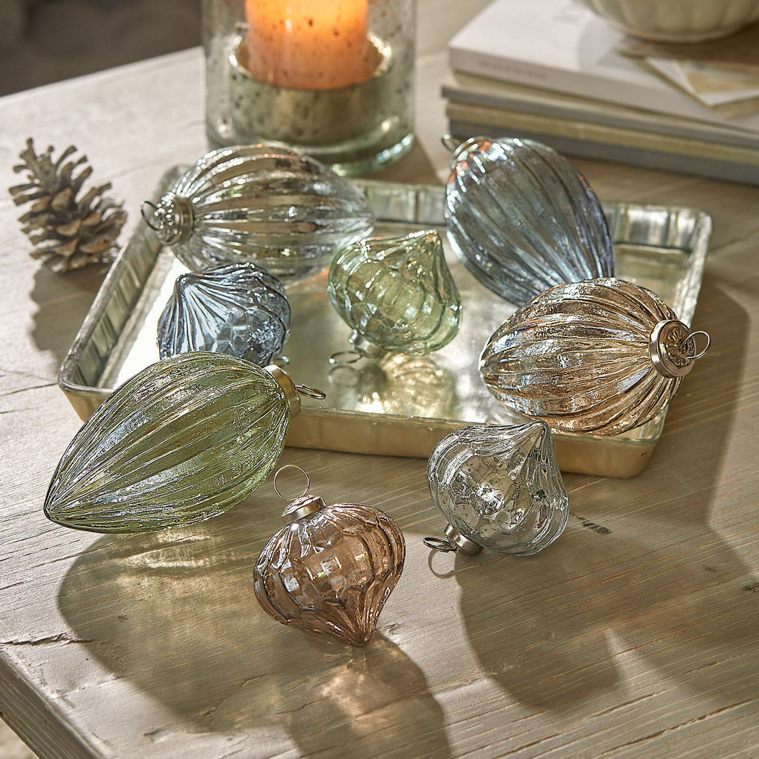 Set de 8 bolas de Navidad Azélisse Conjunto de adornos navideños de vidrio en varios colores y formas sobre mesa de madera