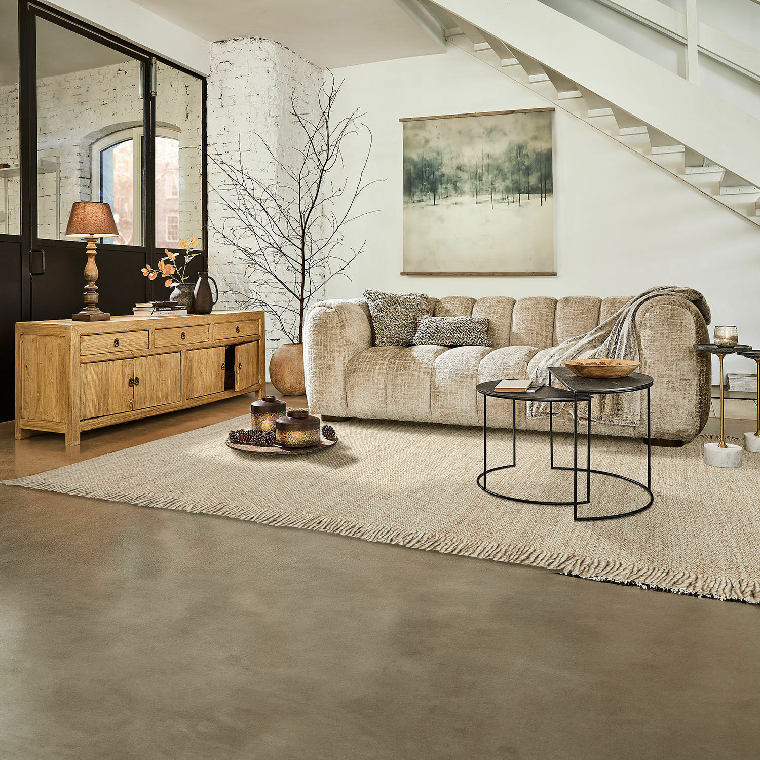 Alfombra Levraut Sofá beige de tela en salón moderno con aparador de madera y mesas auxiliares de metal negro