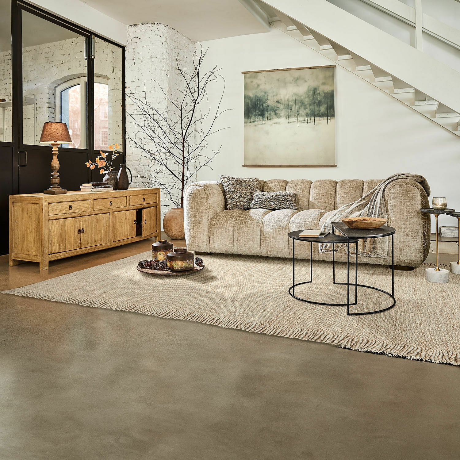 Alfombra Levraut Sofá beige de tela en salón moderno con aparador de madera y mesas auxiliares de metal negro