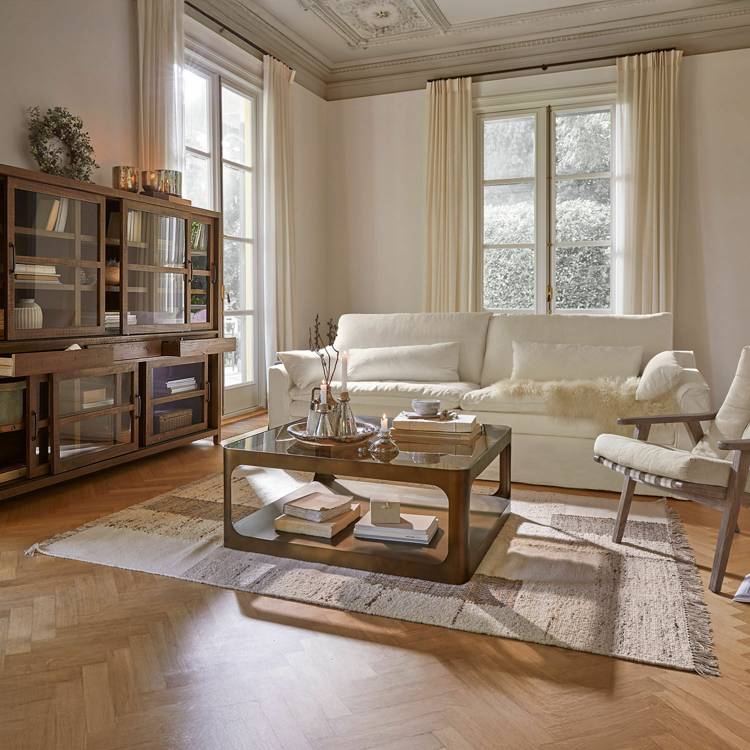 Alfombra Faircliffe Salón acogedor con sofá blanco, vitrina de madera y mesa de centro metálica sobre alfombra