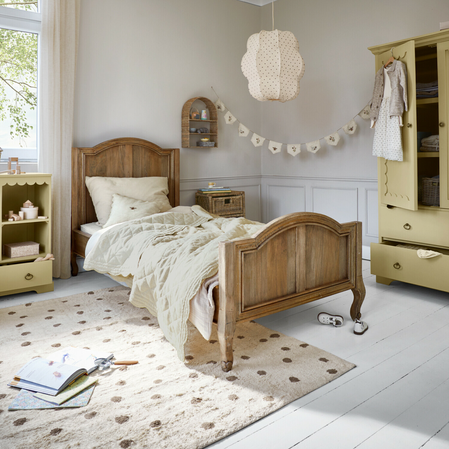 Cama Rêverine Cama infantil de madera con ropa de cama beige y alfombra crema en habitación infantil luminosa
