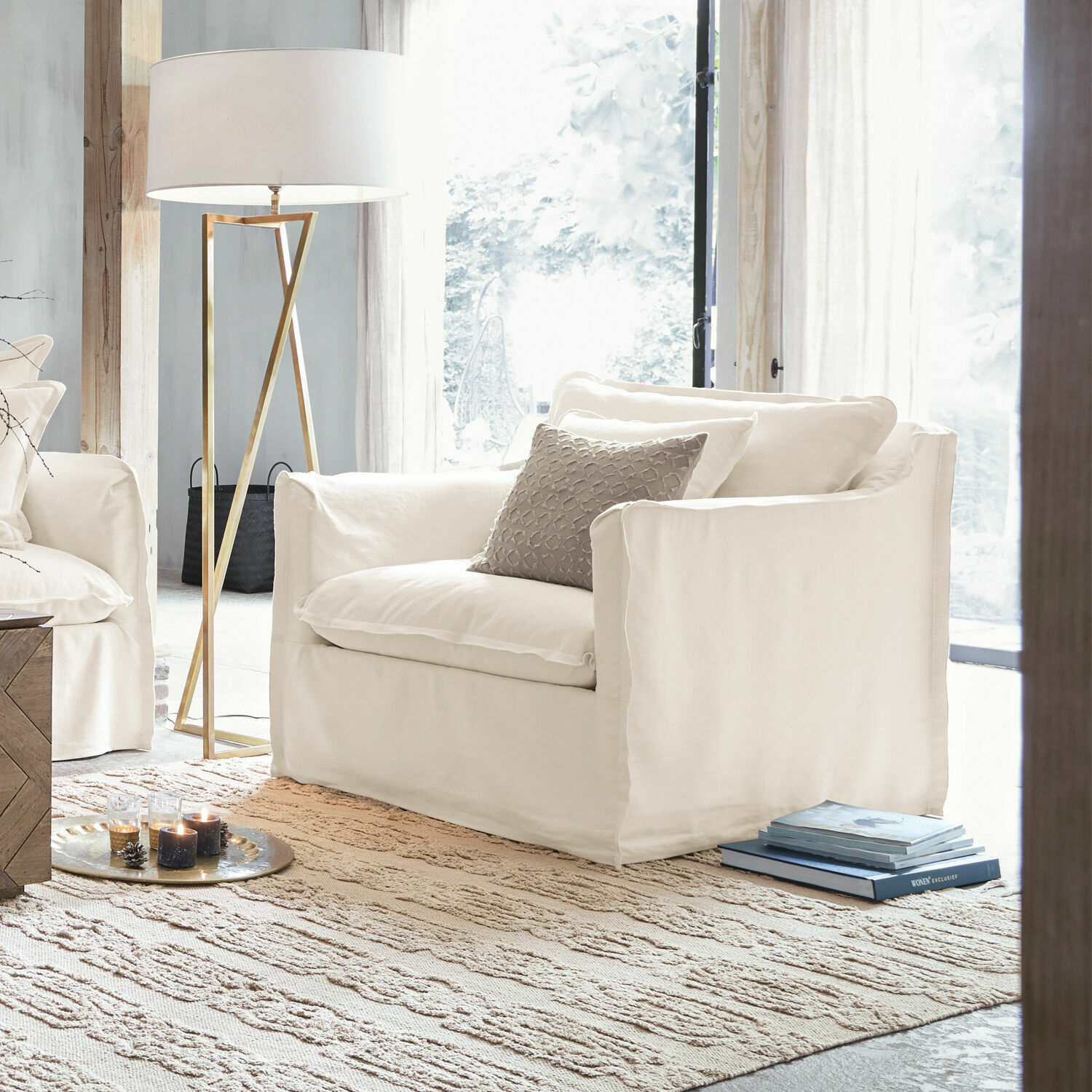 Sillón Tienen Sillón blanco de tela en sala luminosa con lámpara de pie y alfombra, diseño moderno de muebles.