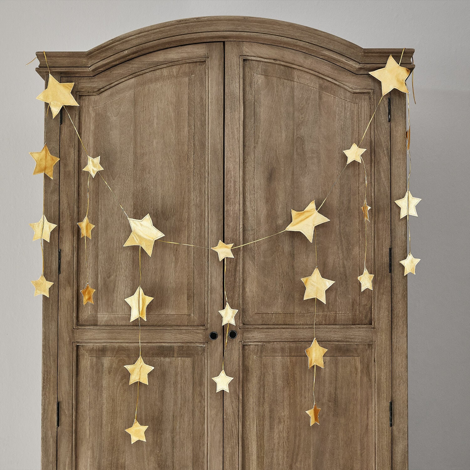Garland Étoilin Guirnalda de estrellas doradas colgada en un armario de madera, decoración navideña para el hogar