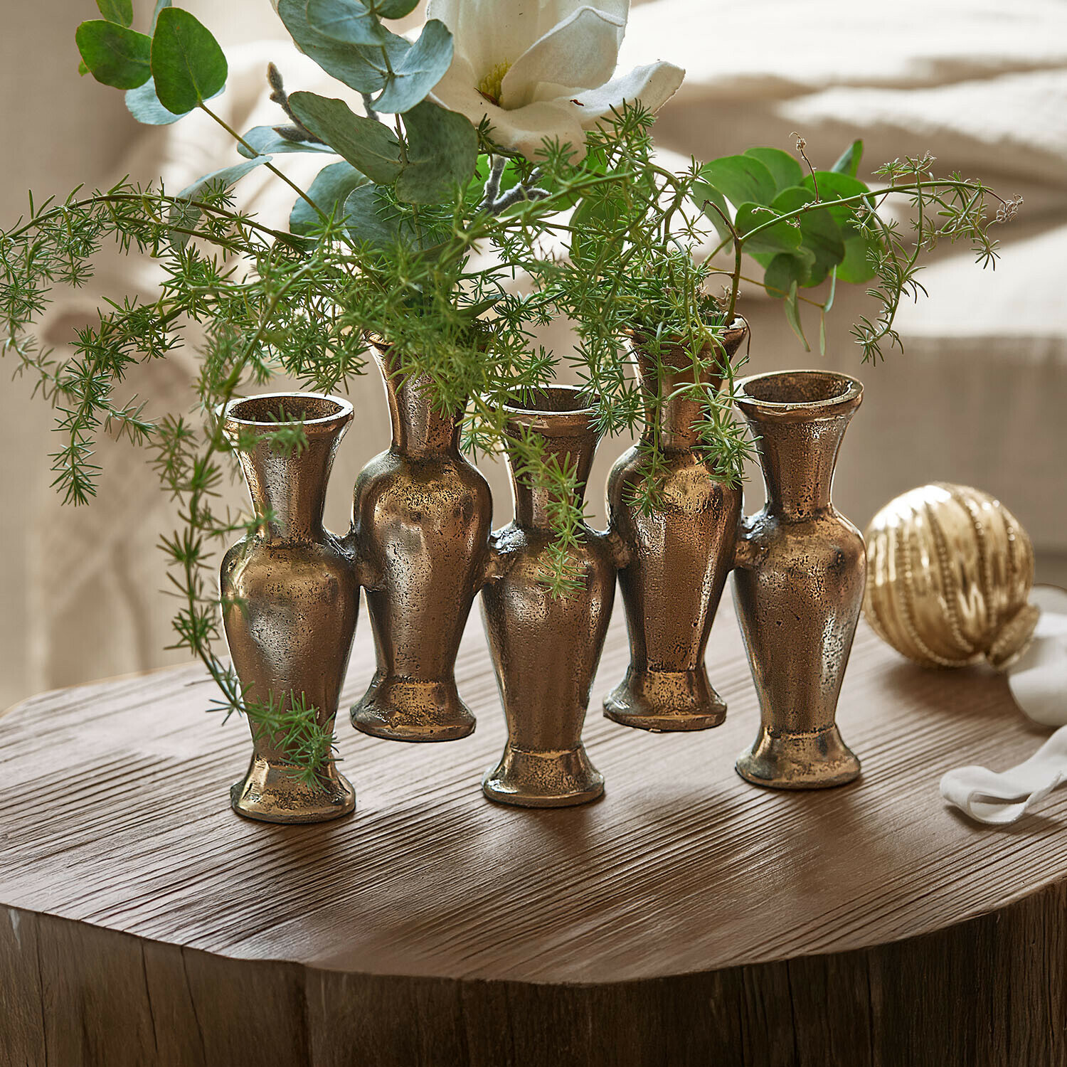 Jarrones Soretta Jarrón decorativo de latón con cinco recipientes unidos para plantas verdes sobre mesa de madera