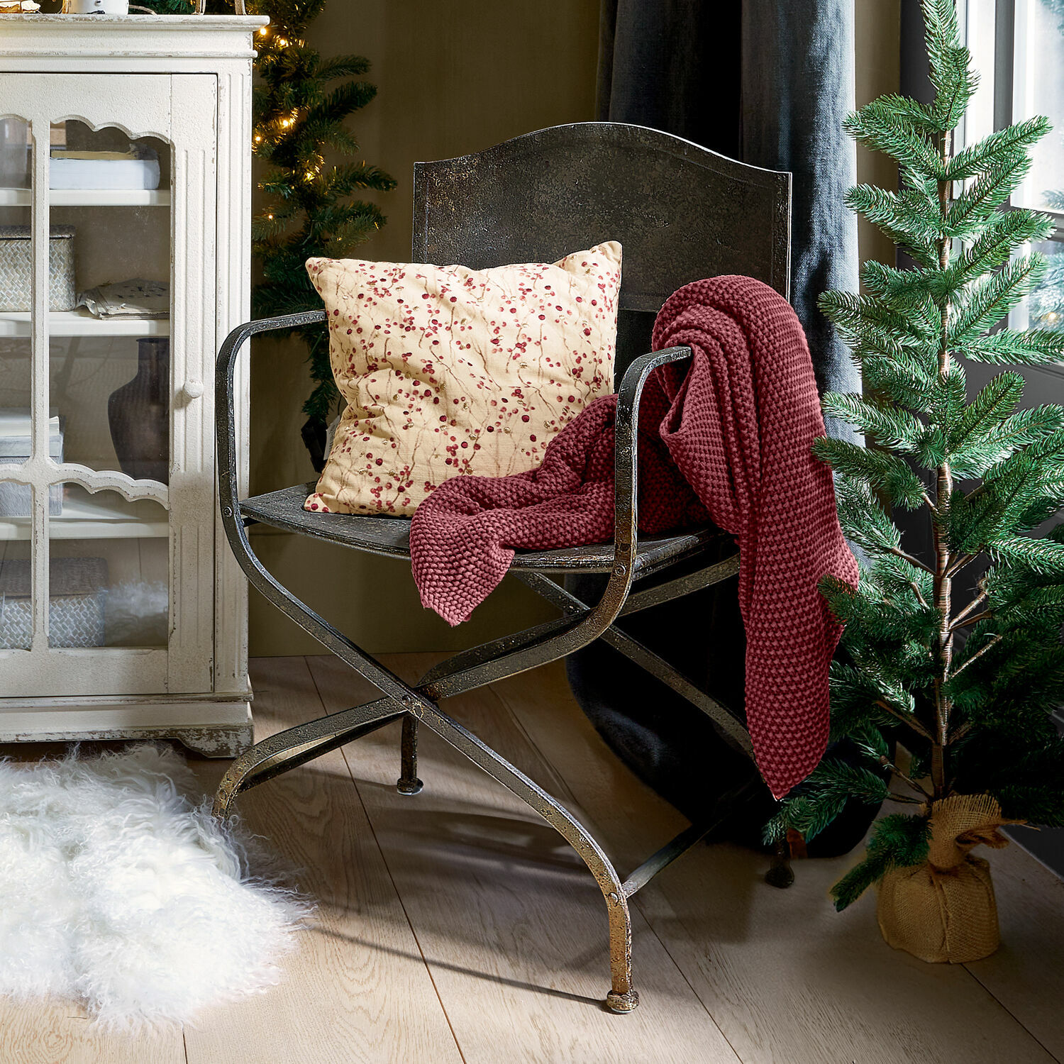 Silla Ivilique Silla de metal con cojín de bayas rojas y manta burdeos en interior acogedor con árbol de Navidad