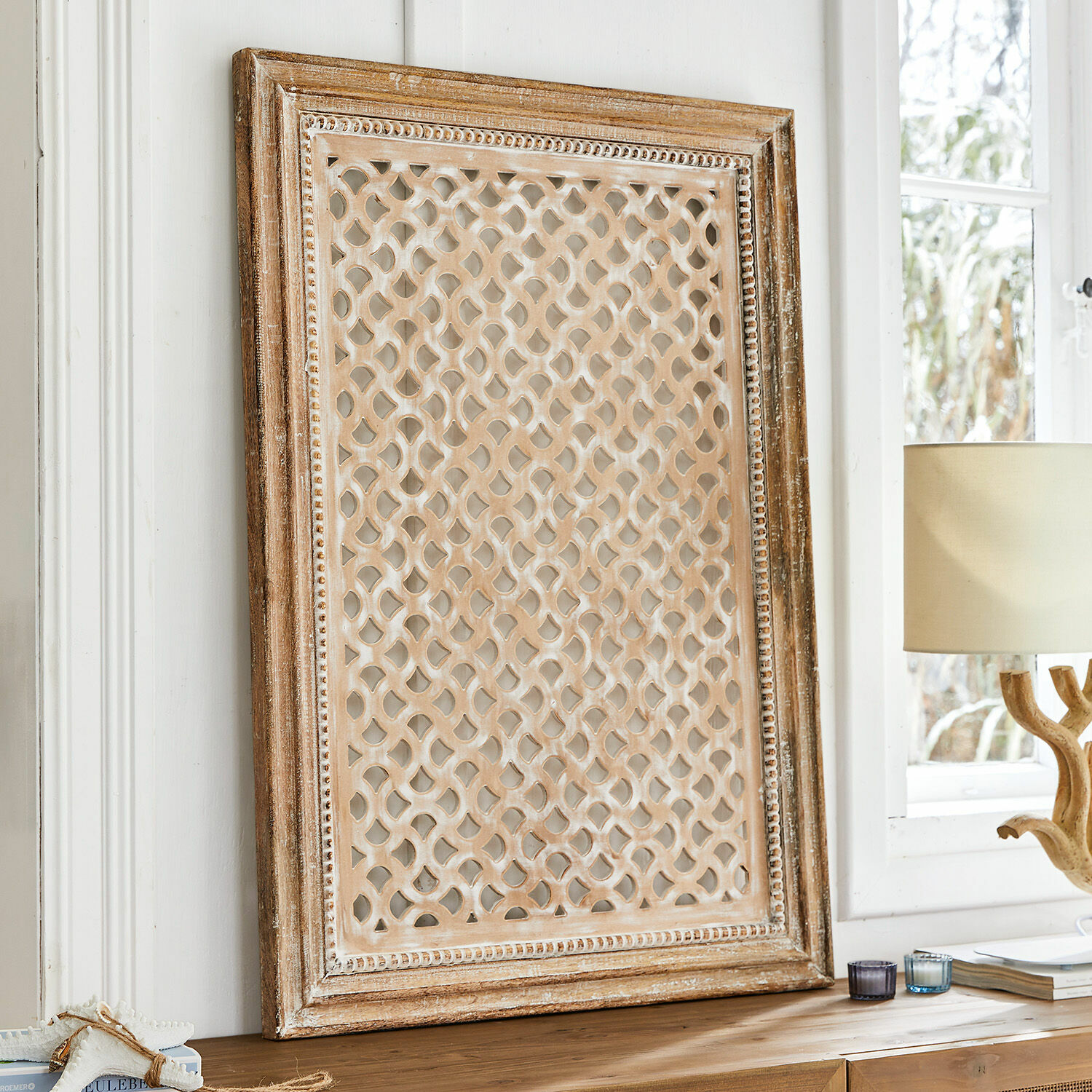 Cuadro Miette Marco decorativo de madera con patrón calado en color marrón claro sobre mesa de madera