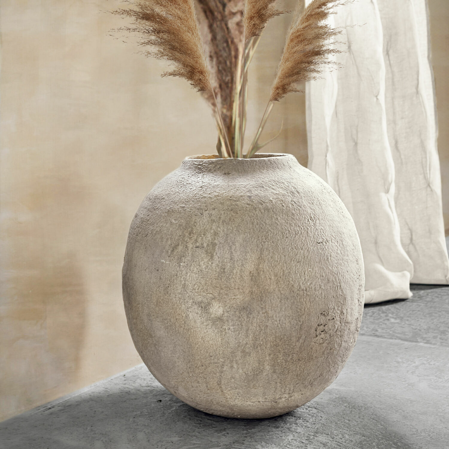 Jarrón Samai Jarrón redondo de hormigón gris con hierbas decorativas en interior moderno