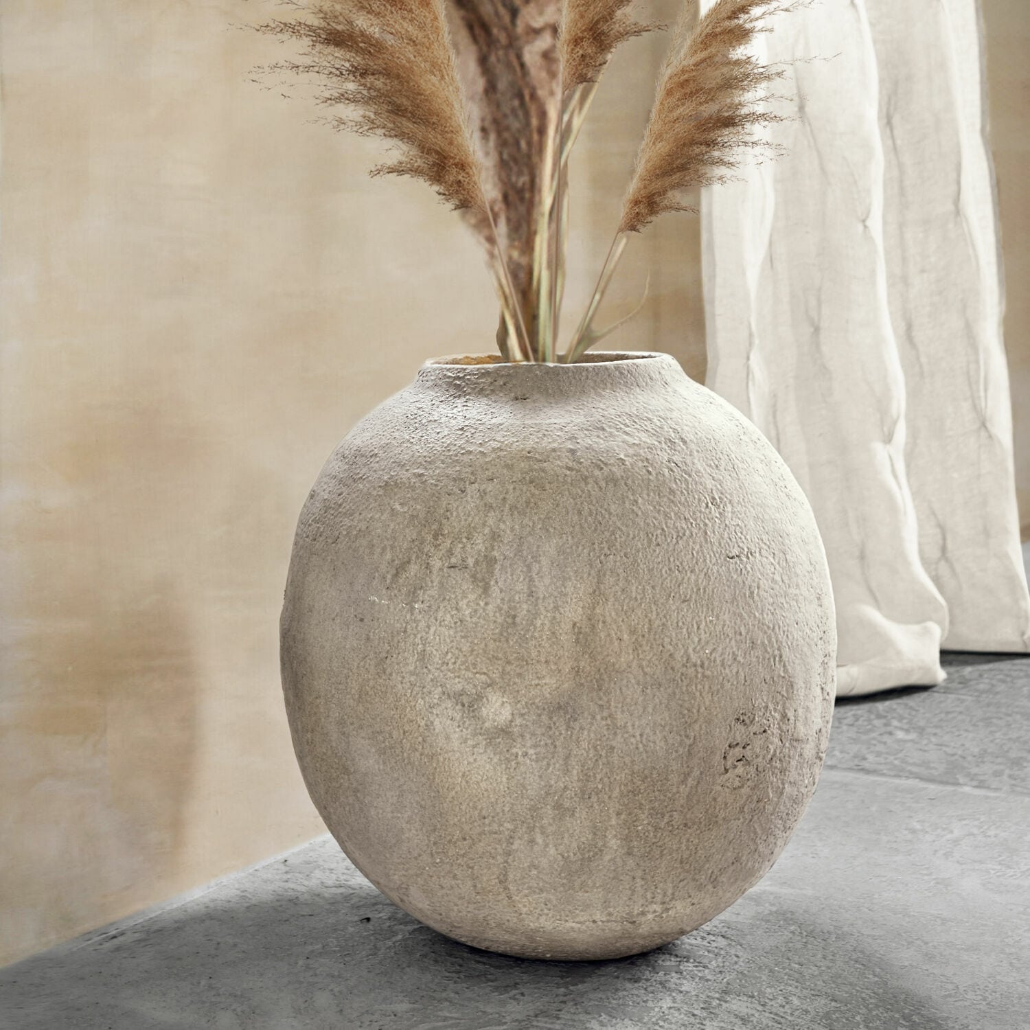 Jarrón Samai Jarrón redondo de hormigón gris con hierbas decorativas en interior moderno