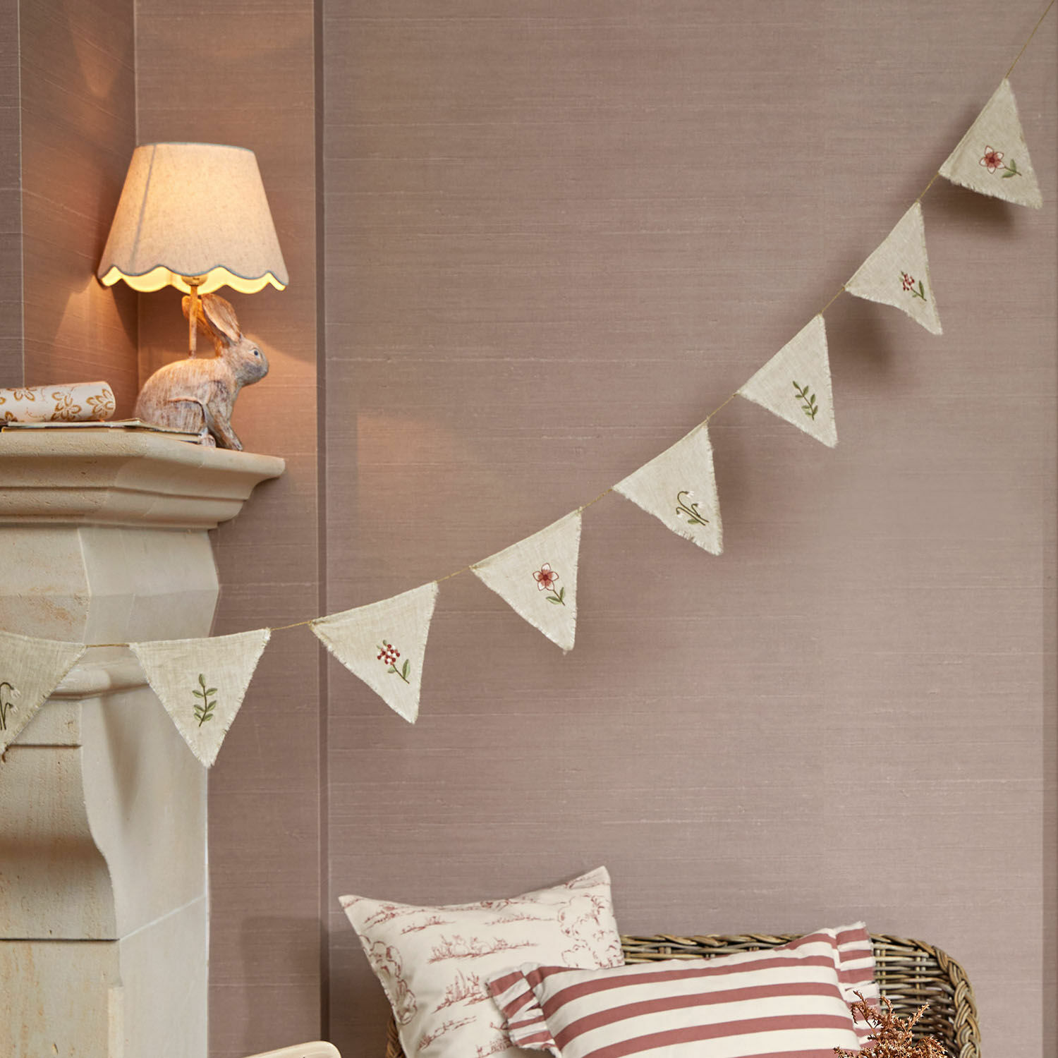 Guirnalda de banderines Viyan Guirnalda decorativa de tela natural con bordados florales sobre fondo beige para interiores