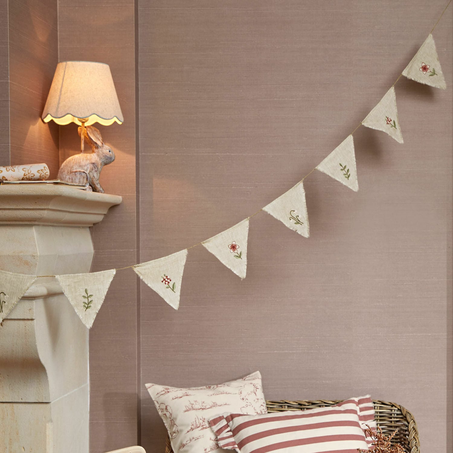 Guirnalda de banderines Viyan Guirnalda decorativa de tela natural con bordados florales sobre fondo beige para interiores