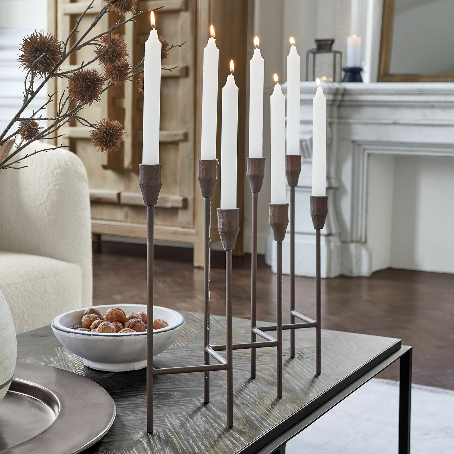 Candelabro Brissande Candelabro de metal con ocho velas blancas sobre mesa en sala moderna