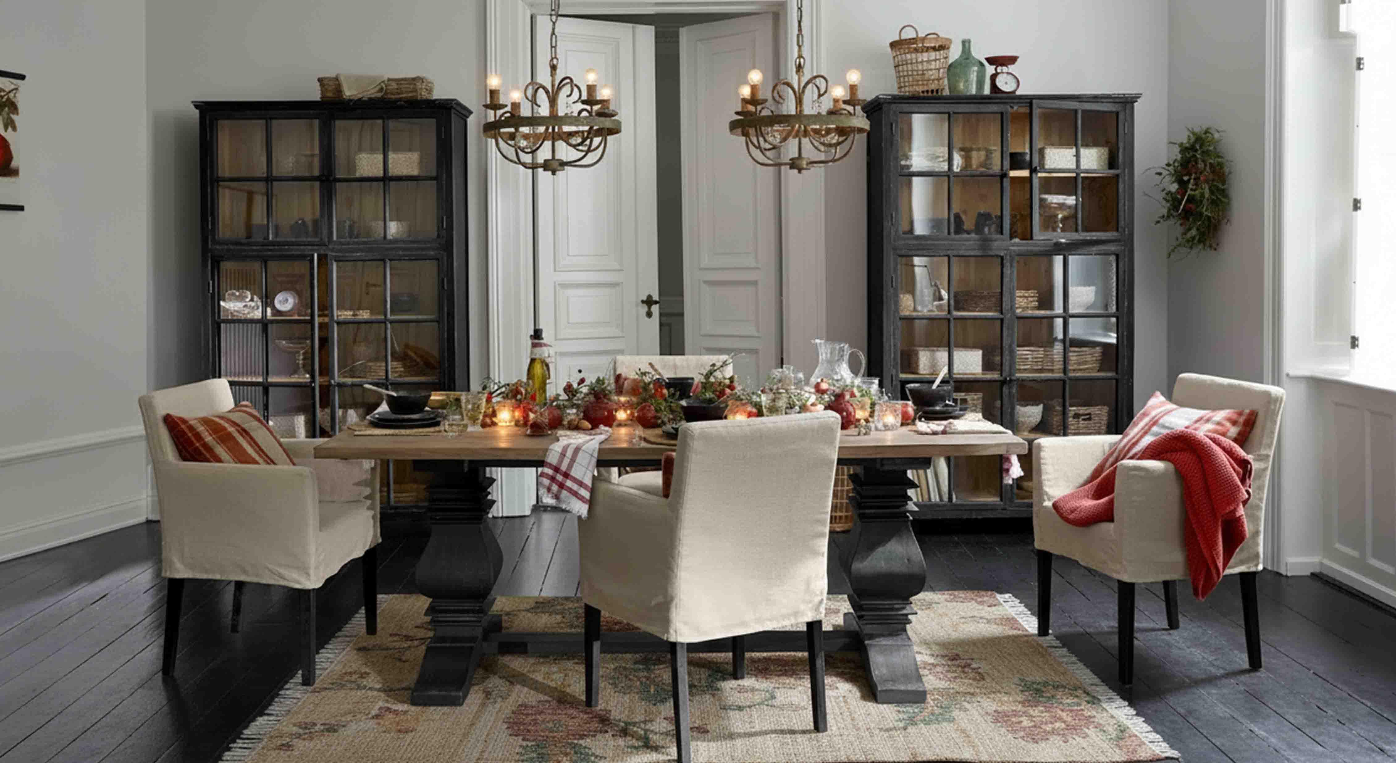 Comedor con mesa de madera y sillas crema, decoración rústica y lámparas colgantes