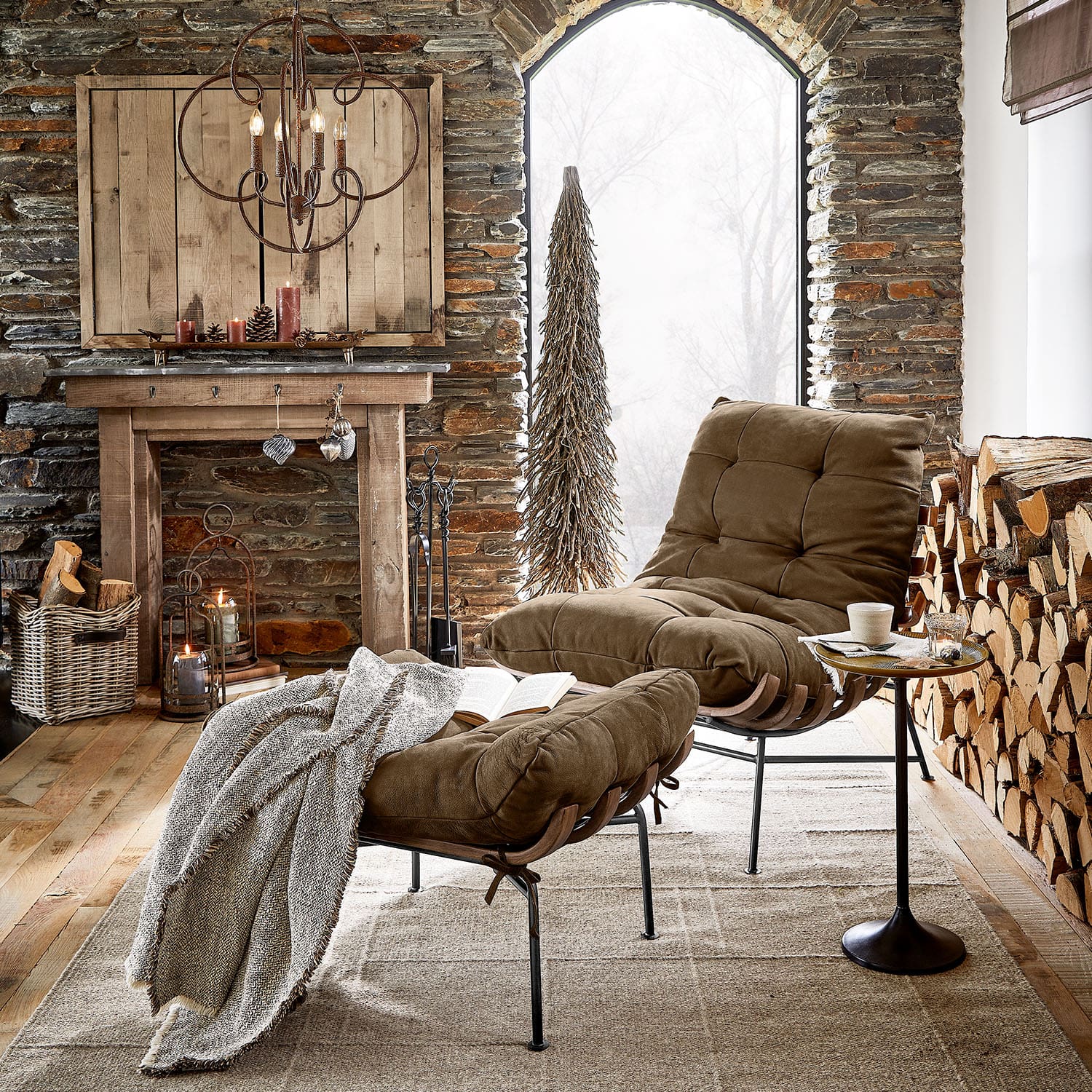 Sillón marrón con reposapiés y estructura metálica en salón rústico con chimenea y leña