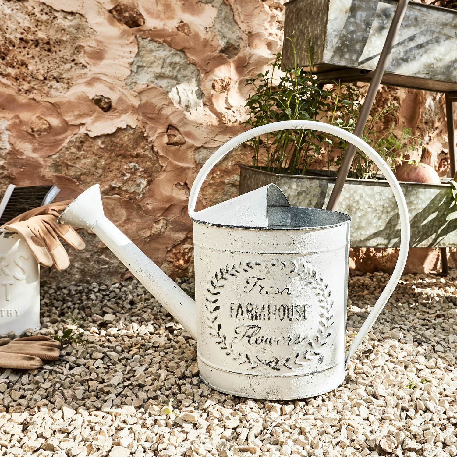 Regadera Farmhouse Regadera metálica blanca con inscripción Farmhouse sobre suelo de grava para jardinería y riego