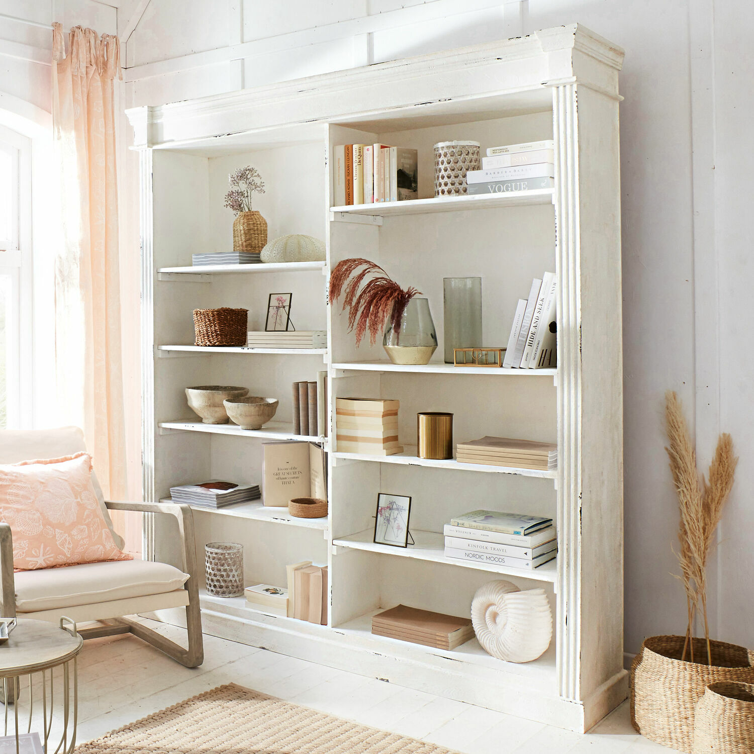 Estante Barrow Creek Estantería de madera blanca con decoraciones y libros en salón luminoso y acogedor con detalles naturales
