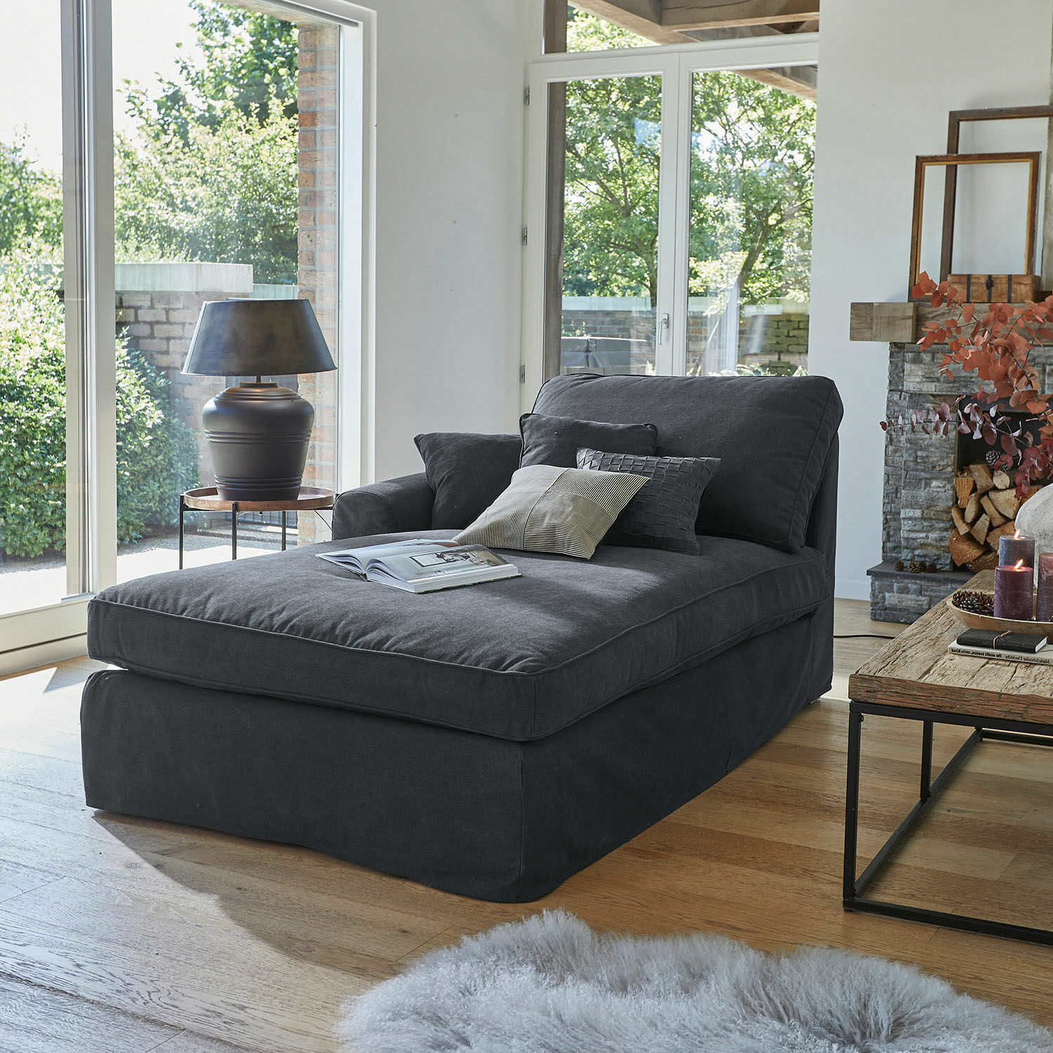 Chaise longue Seaford Chaise longue tapizada gris oscuro con cojines en sala moderna con suelo de madera