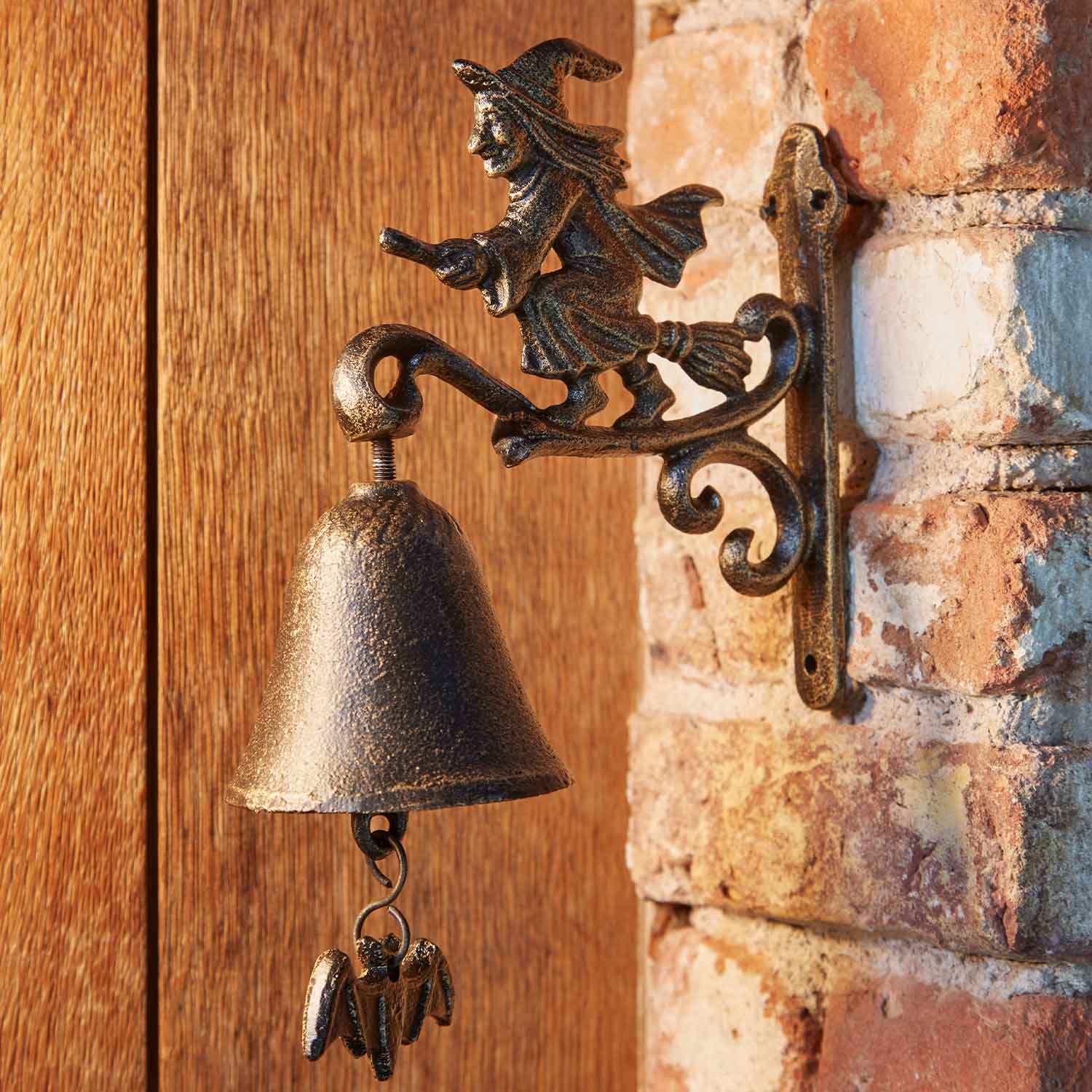 Campana de metal con figura de bruja en escoba en tono bronce antiguo para decoración de puerta y jardín