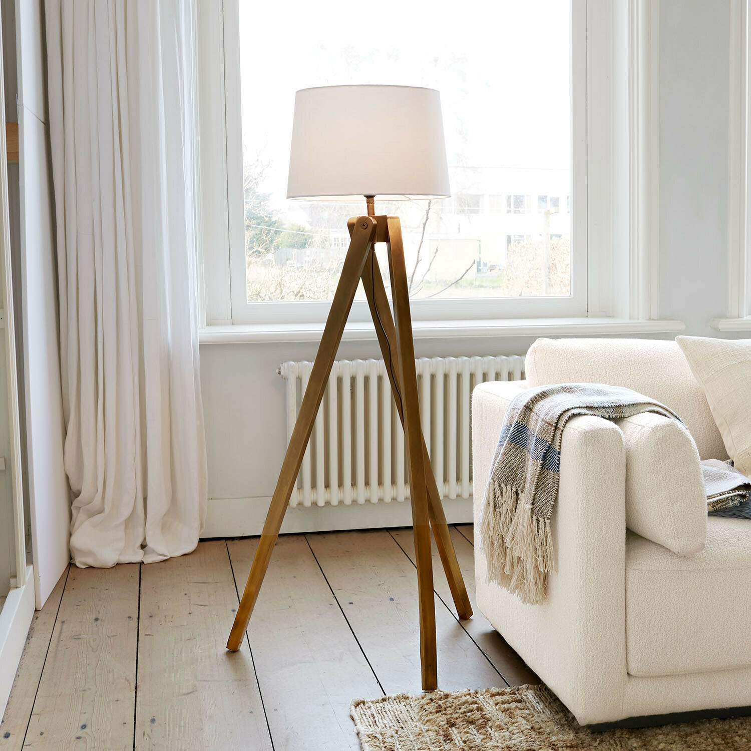 Lámpara de pie Kelvio Lámpara de pie con base de madera y pantalla blanca en salón luminoso con sofá beige