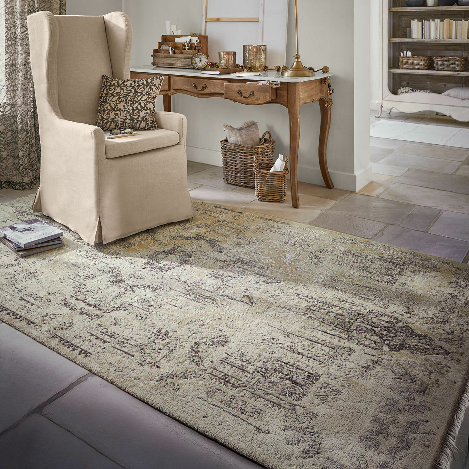 Alfombra Marzahan Alfombra beige con diseño vintage en sala con sillón beige y escritorio de madera, decoraciones y libros