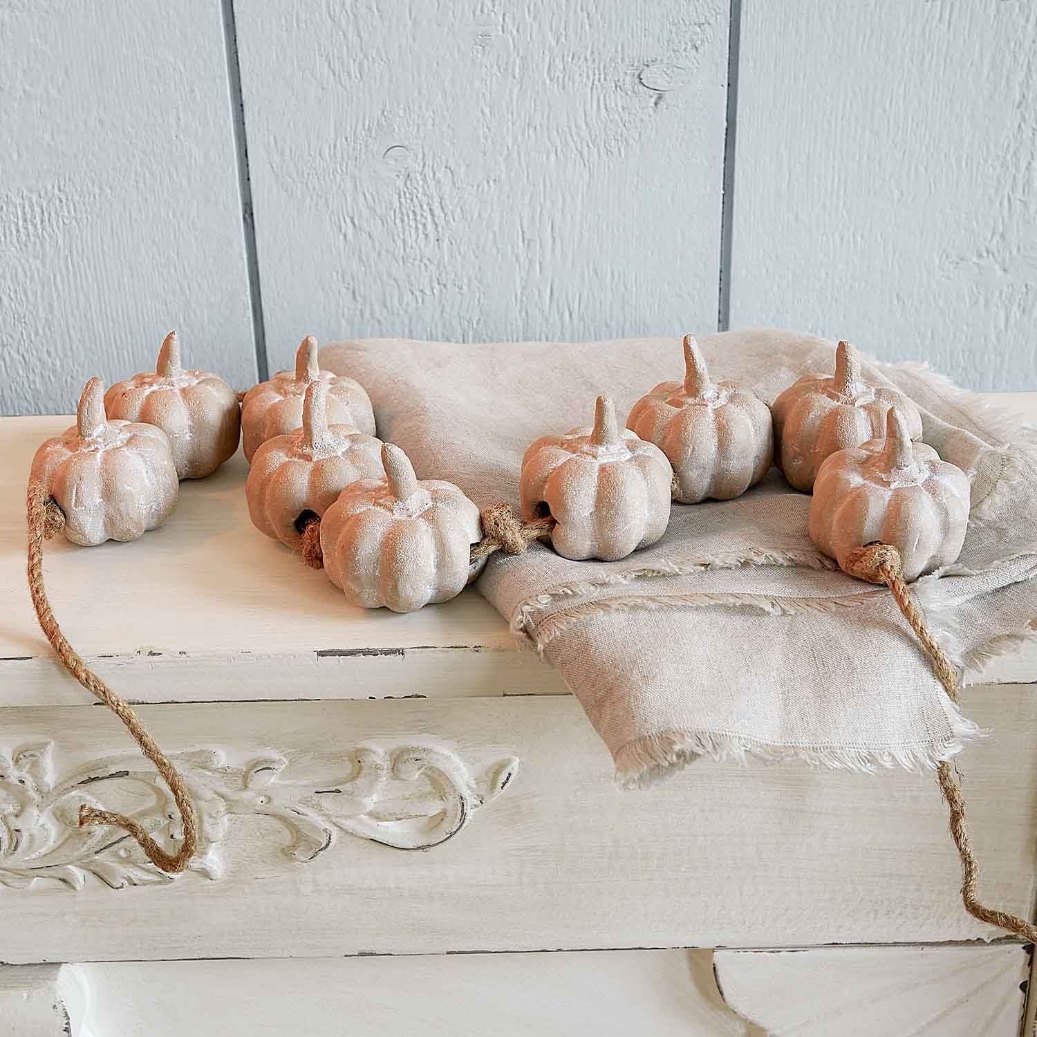 Guirnalda decorativa de calabazas de cerámica beige en cuerda para decoración otoñal