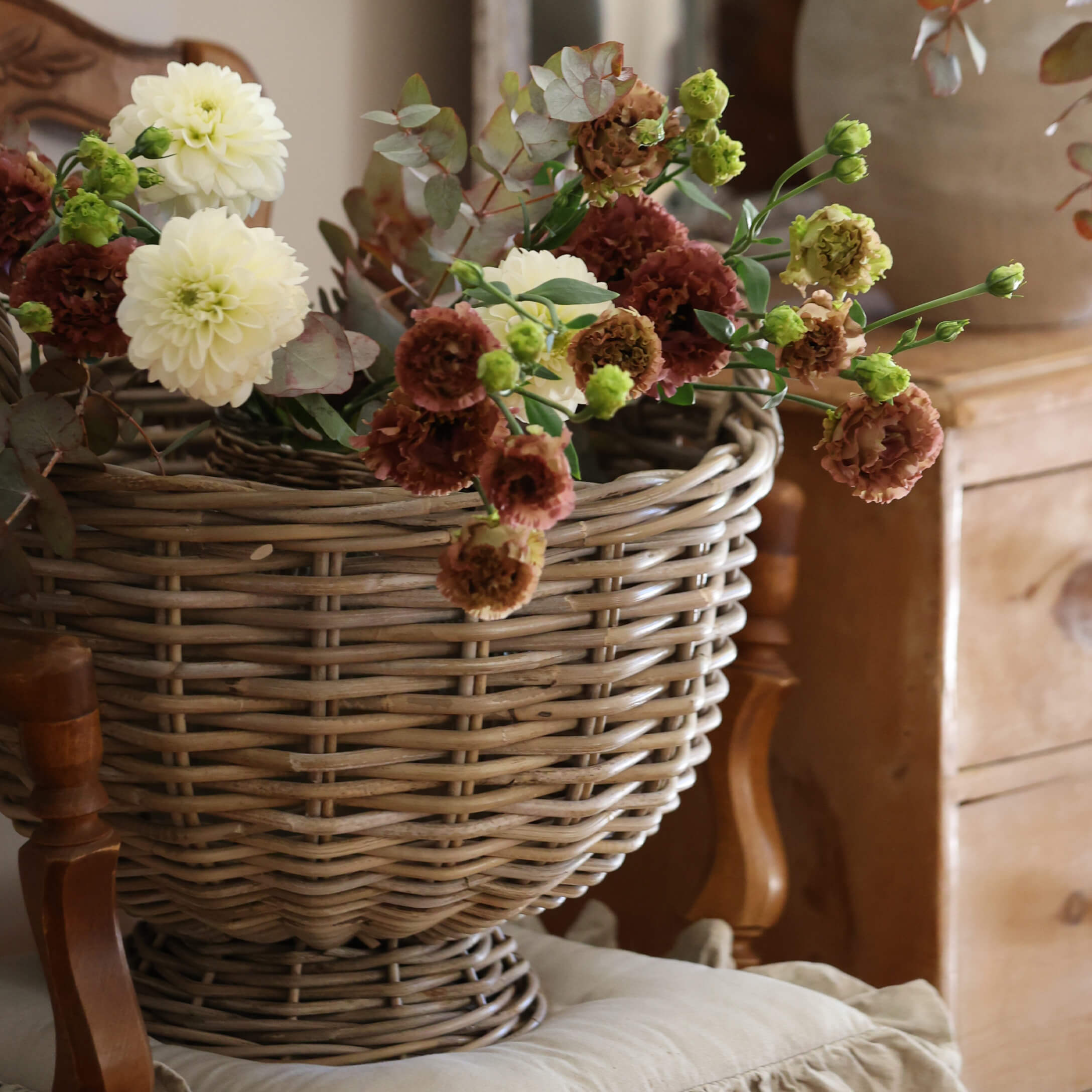 Cesta decorativa de mimbre con flores crema y marrón para interiores de estilo vintage