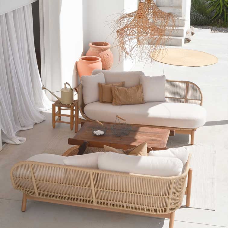 Conjunto de muebles de exterior de ratán natural con cojines crema y mesa de madera