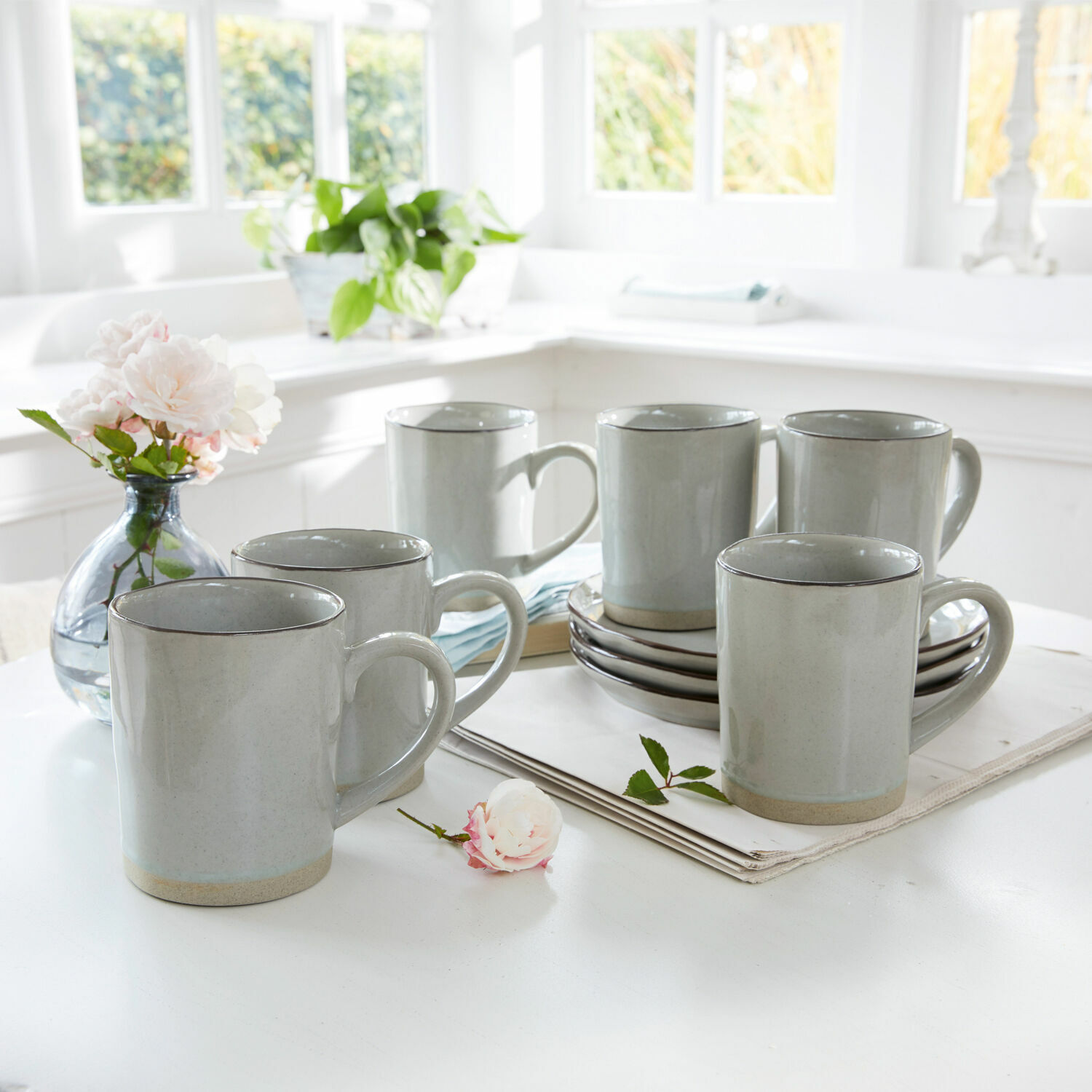 Set de 6 tazas Biarré Conjunto de seis tazas de cerámica gris con asa sobre mesa clara en interior luminoso