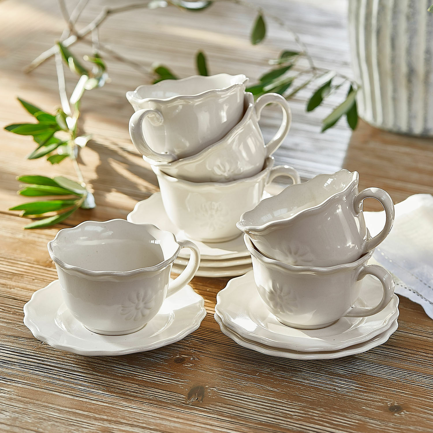 Set de 6 tazas con platillos Mallevesse Juego de tazas y platos de cerámica blanca con diseño delicado sobre mesa de madera