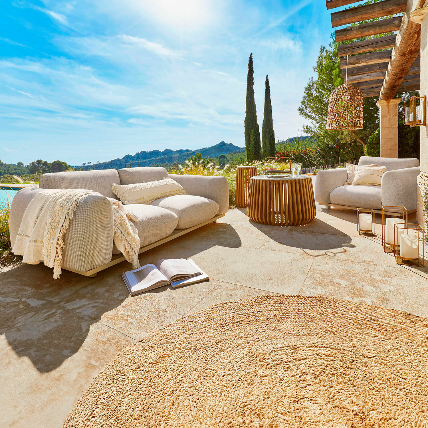 Grupo de asientos Savinard Conjunto de muebles de exterior beige con tela y mesa de madera en terraza soleada con vistas a las montañas