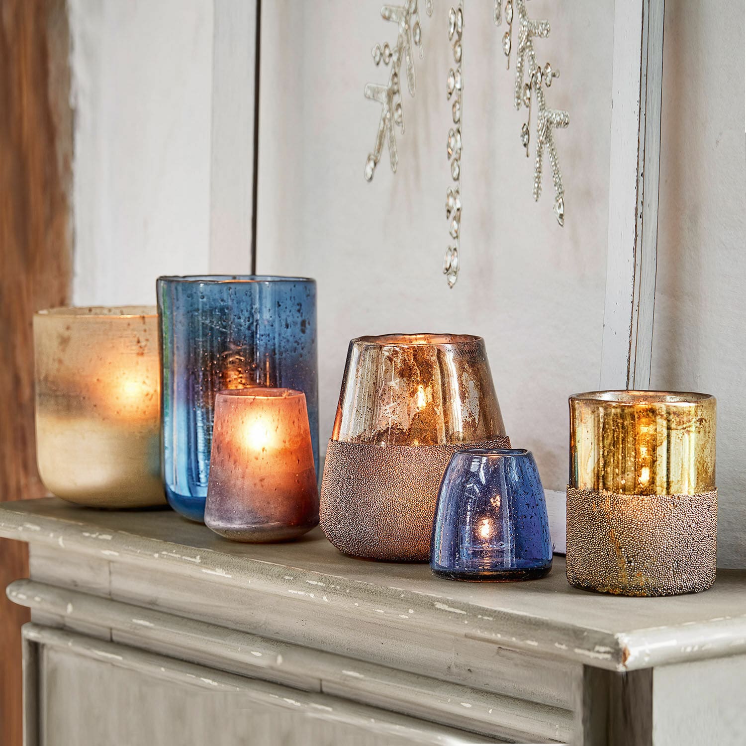Set de 6 portavelas Paro Conjunto de portavelas de vidrio azul y dorado sobre cómoda, decoración interior elegante