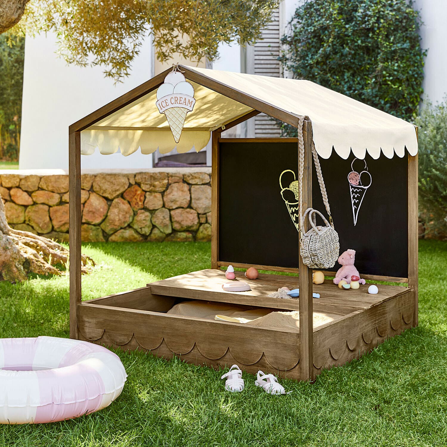 Caja de arena de madera con toldo beige y pizarra, juguetes y decoración de helados para niños
