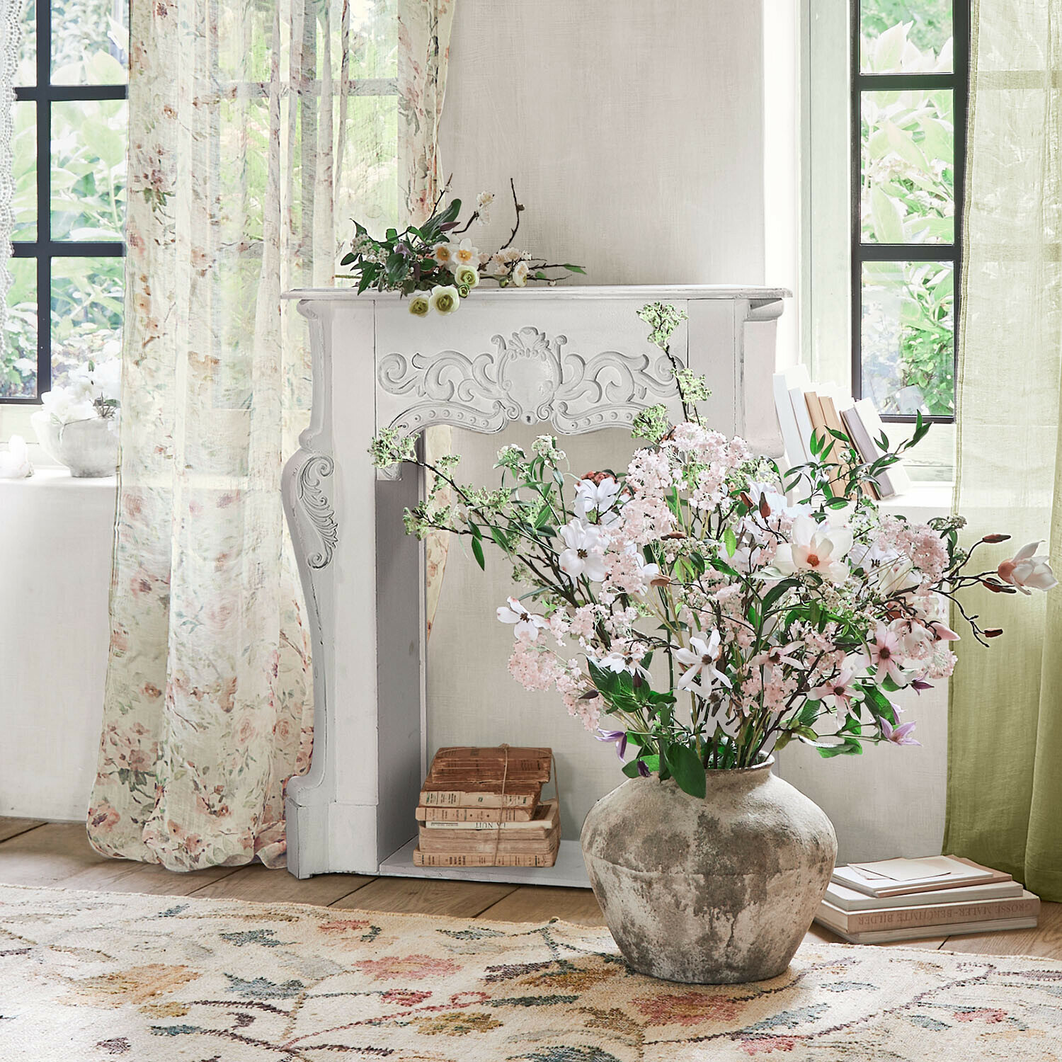 Consola de chimenea Emporia Jarrón grande de cerámica gris con ramo de flores rosas y blancas en sala luminosa con chimenea decorativa