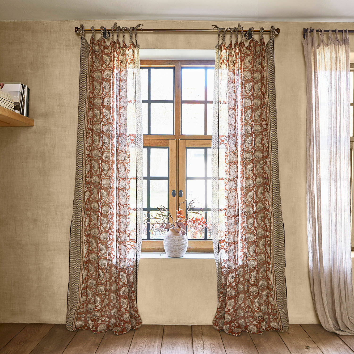 Cortina Lemisto Cortinas transparentes con patrón floral en tonos cálidos en ventana con marco de madera