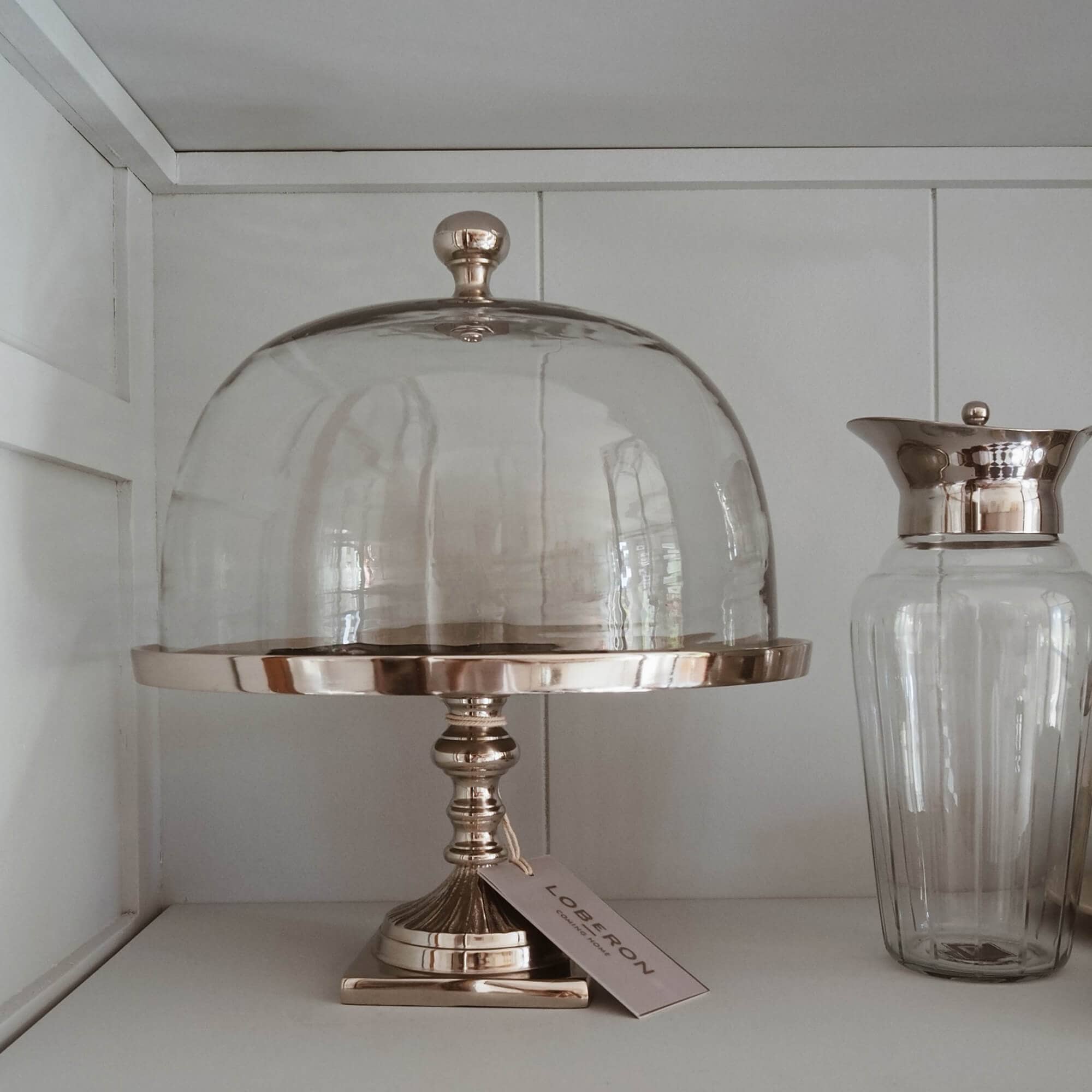 Campana de cristal sobre base metálica dorada para servir pasteles y postres en estilo slow living