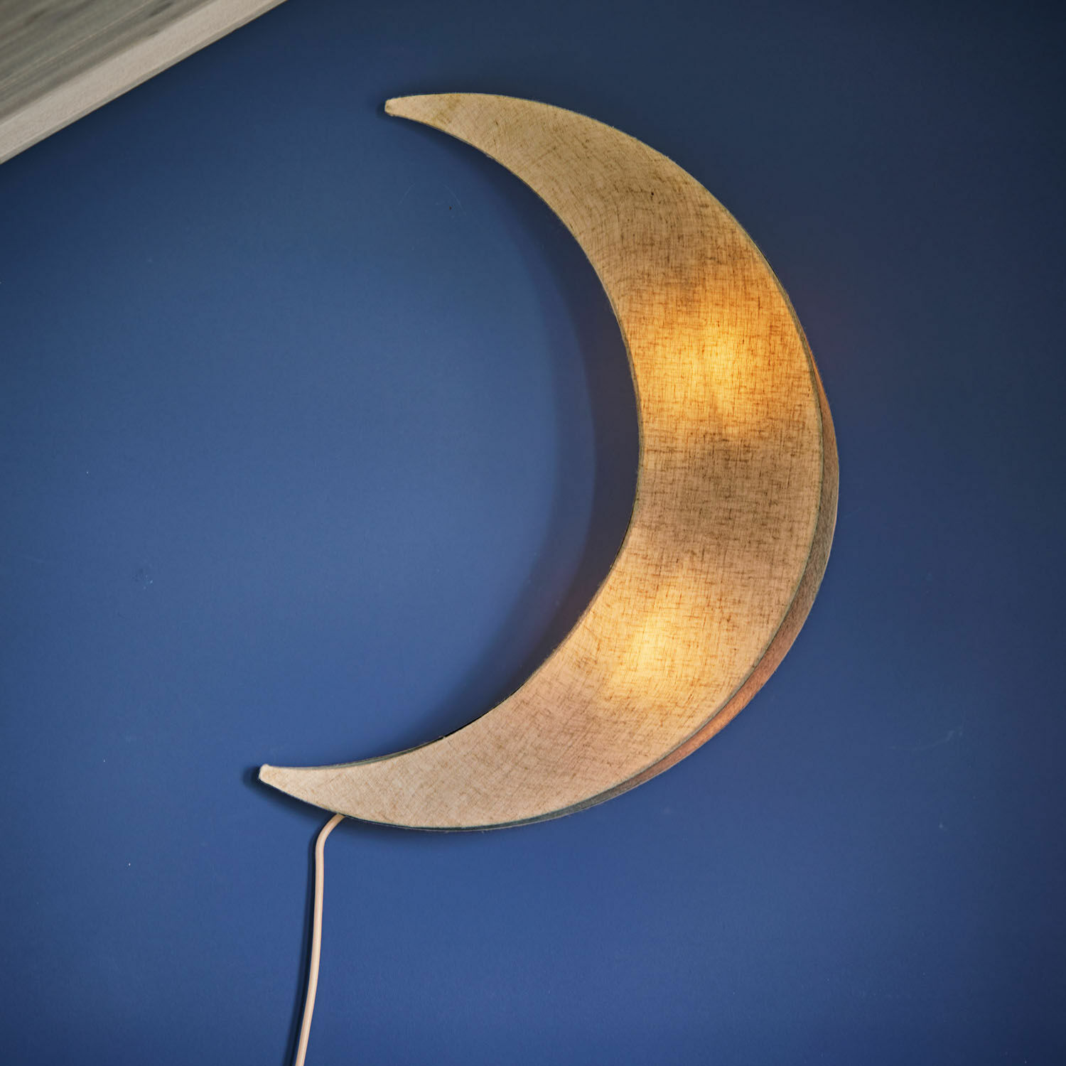 Lámpara de pared Jollymoon Lámpara de pared con forma de luna en tejido beige sobre pared azul