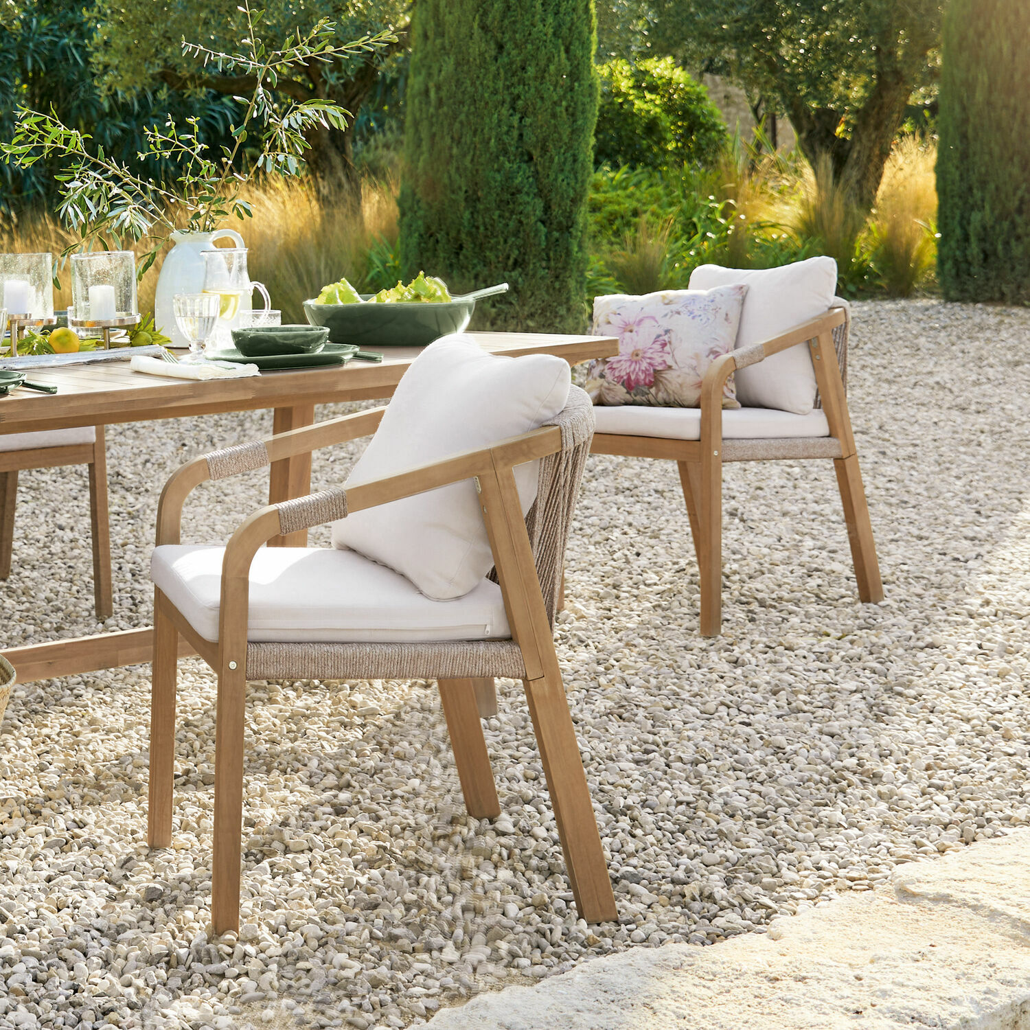 Sillas de jardín de madera con cojines claros en patio de grava, muebles de exterior naturales