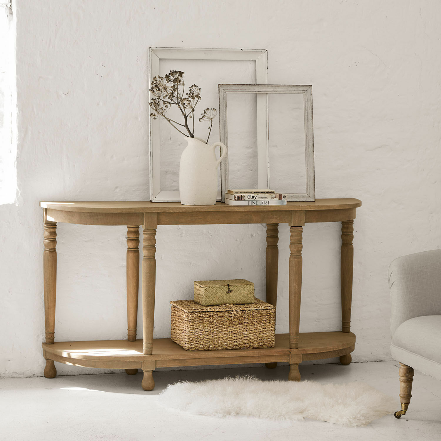 Consola Brookdale Consola de madera natural con marcos decorativos y jarrón con flores secas en interior luminoso
