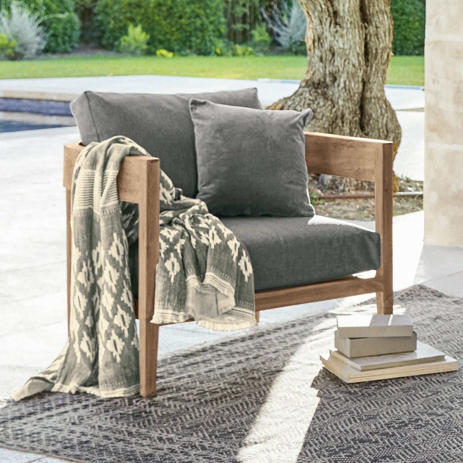 Sillón Courtelevant Sillón con estructura de madera y cojines grises, con manta estampada en exterior
