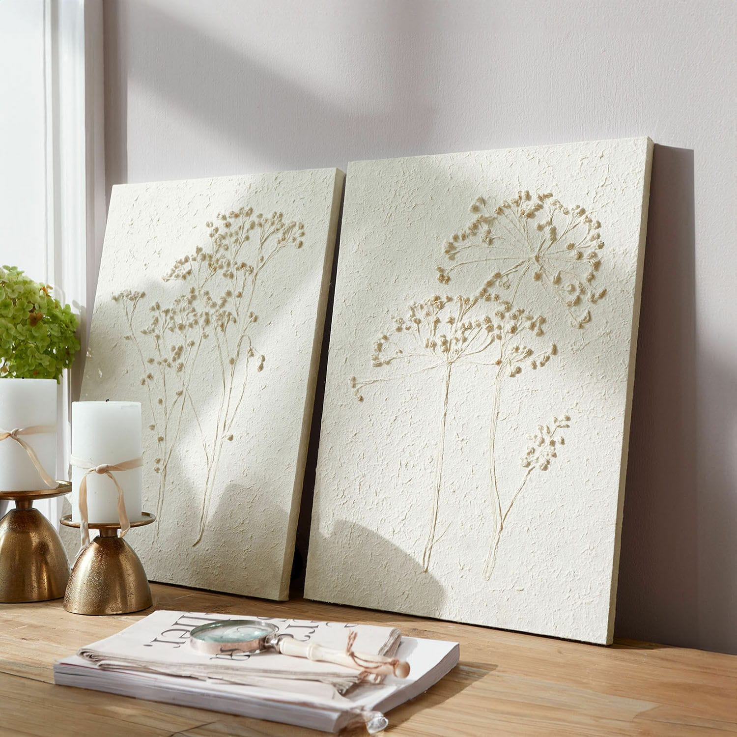 Set de 2 cuadros Tiloren Paneles decorativos crema con relieve de plantas sobre mesa de madera clara