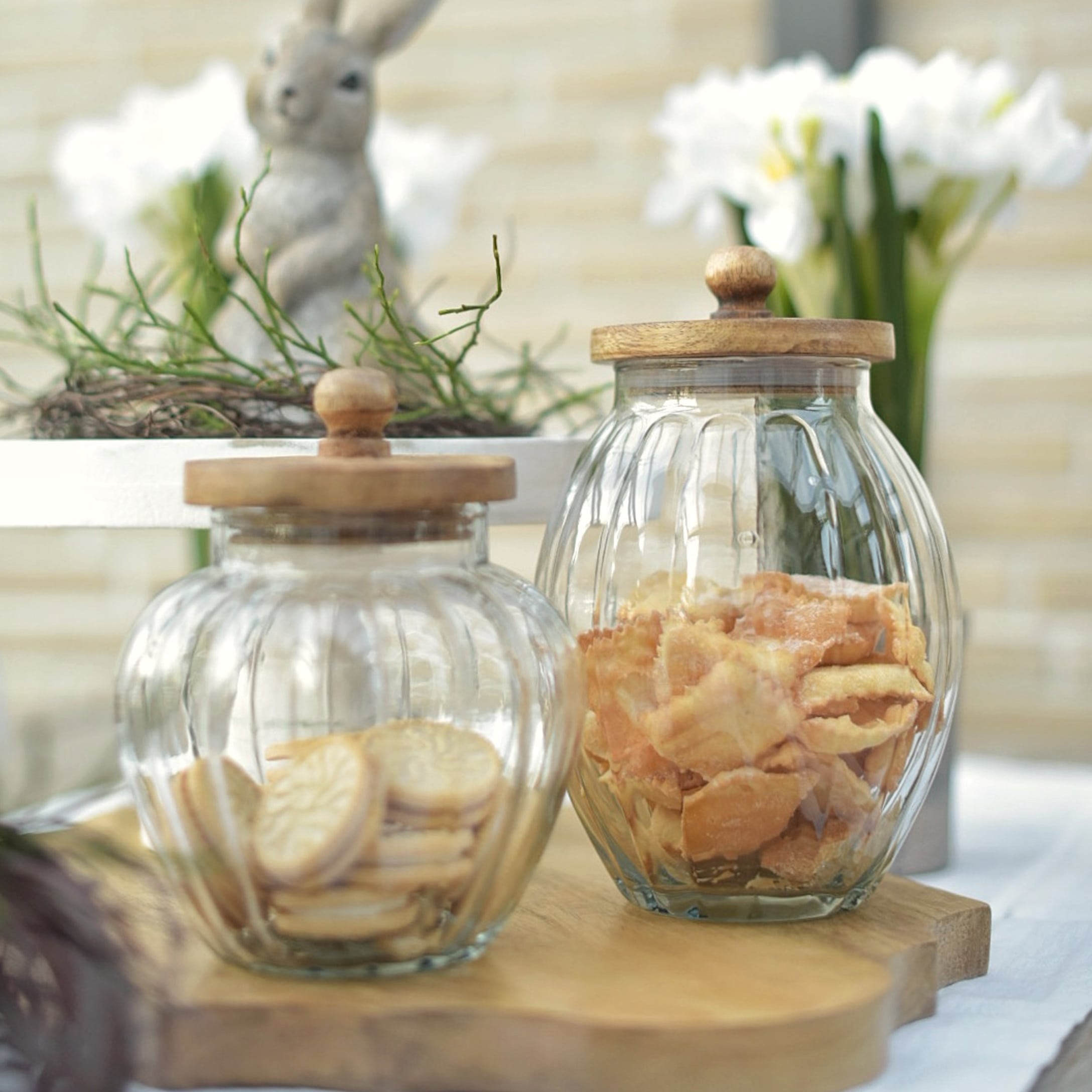 Tarros de vidrio con tapas de madera llenos de galletas, decoración natural de Pascua