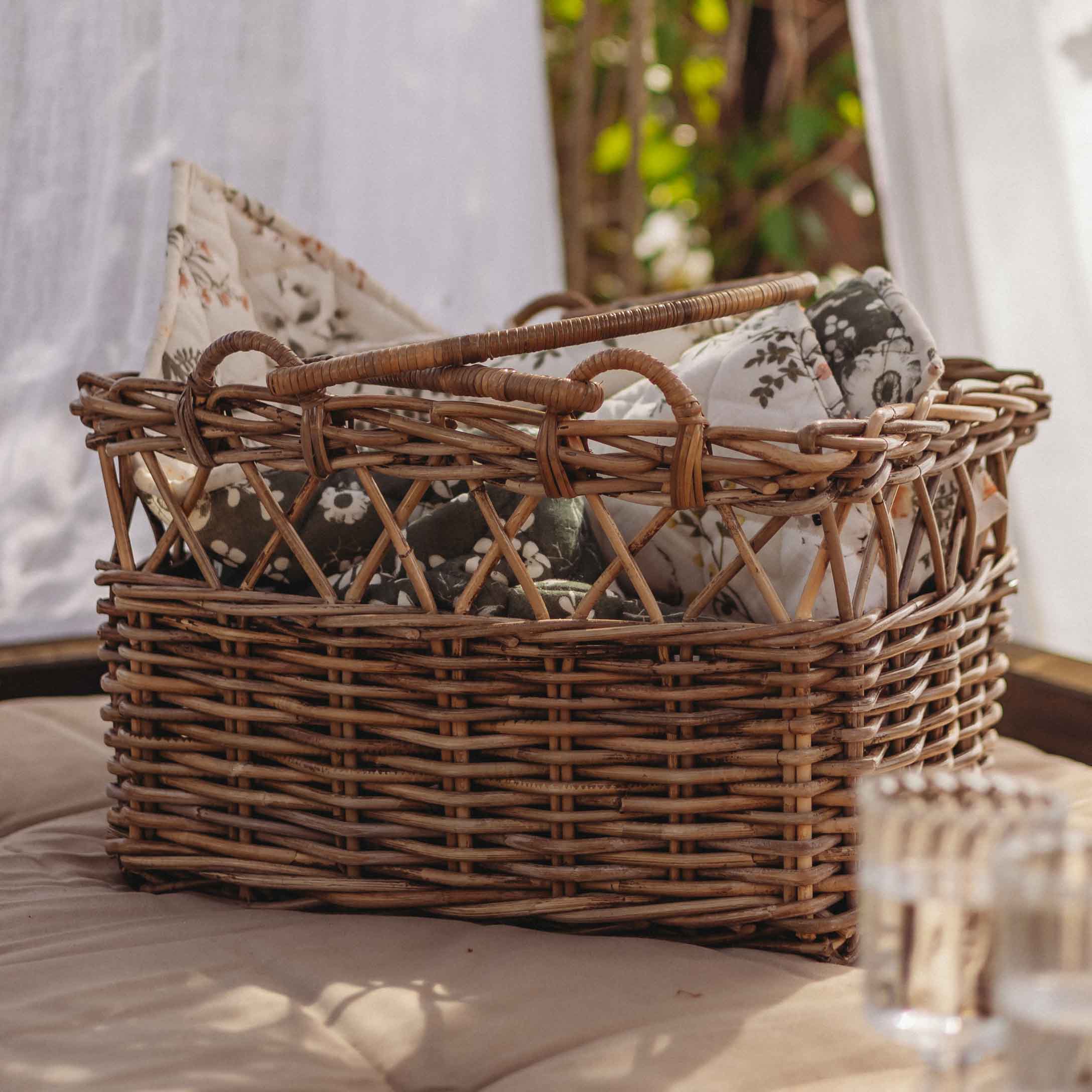 Cesta de mimbre marrón natural con cojines de flores, decoración y almacenamiento para el hogar