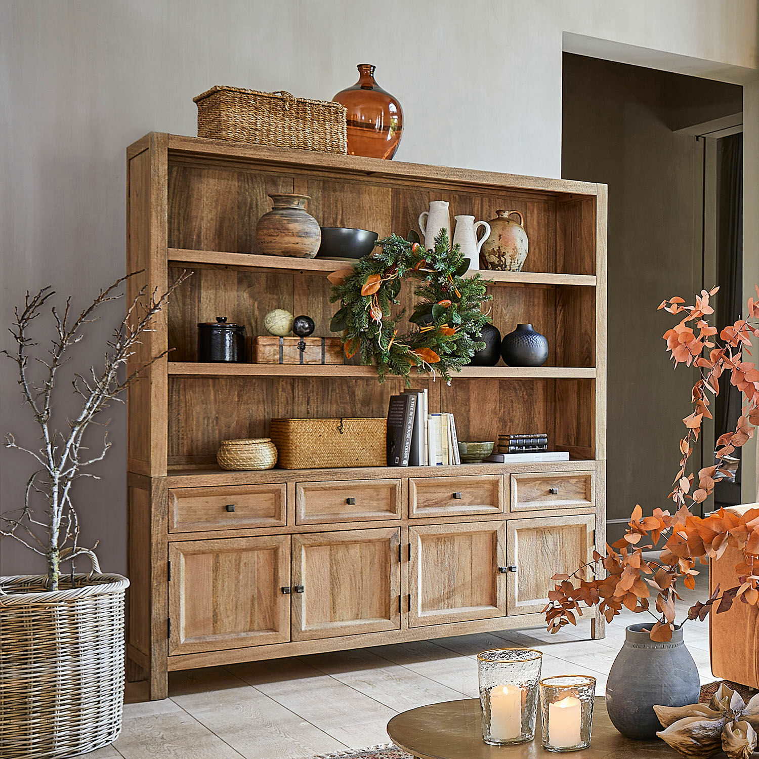 Armario New Bedford Aparador de madera natural con estantes y cajones decorado con jarrones, libros y velas en salón