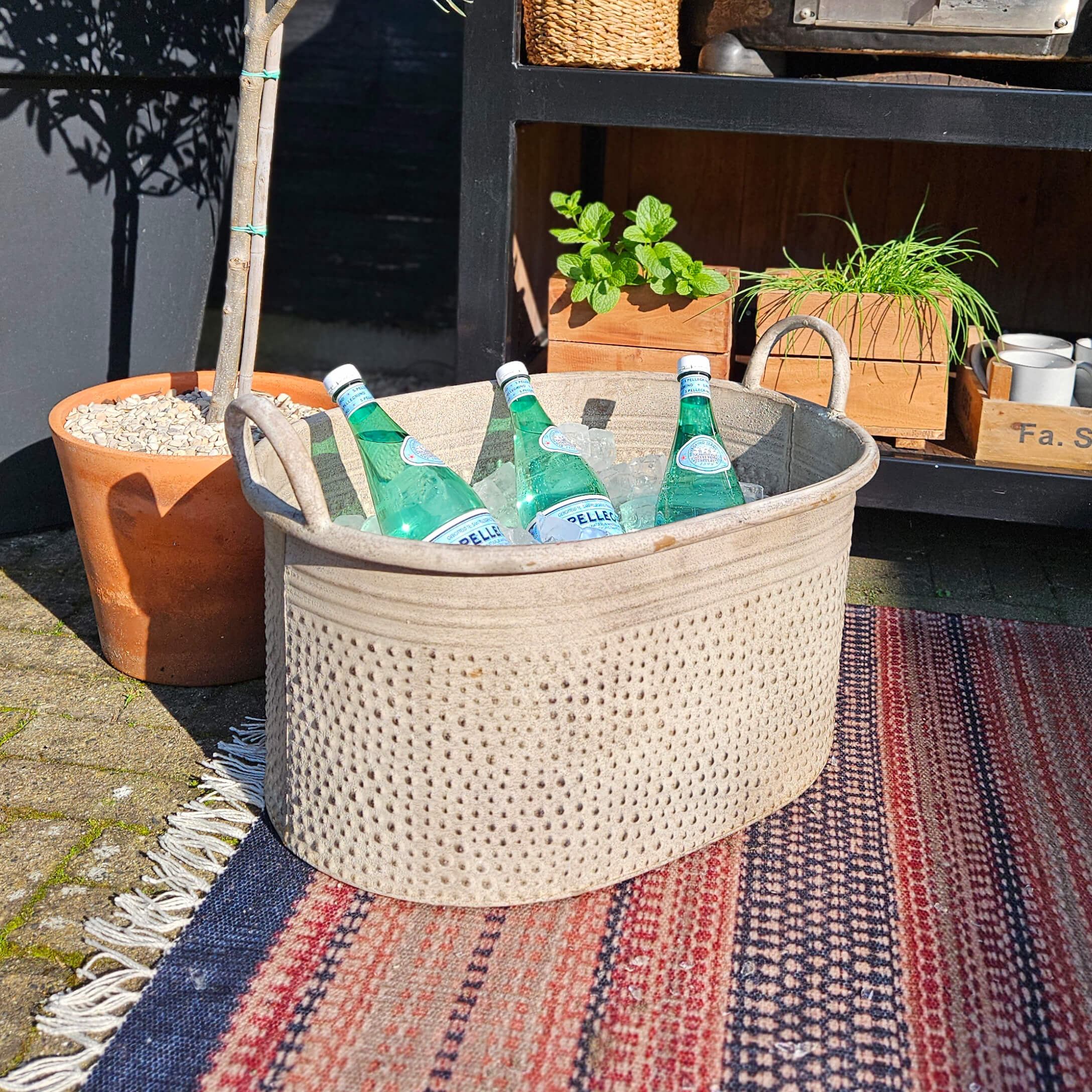 Cesta beige de tela con asas con botellas de agua mineral sobre hielo en exterior