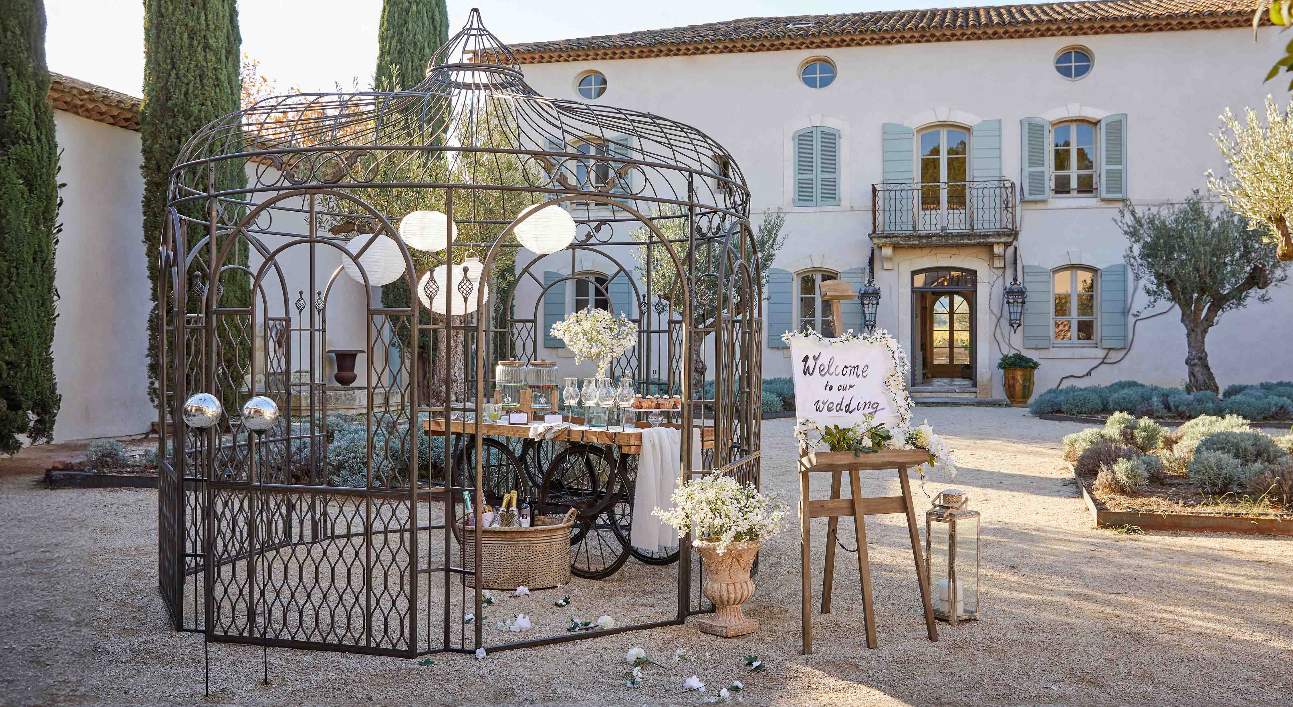 Pérgola metálica decorativa en jardín con mesa y flores para celebración de boda