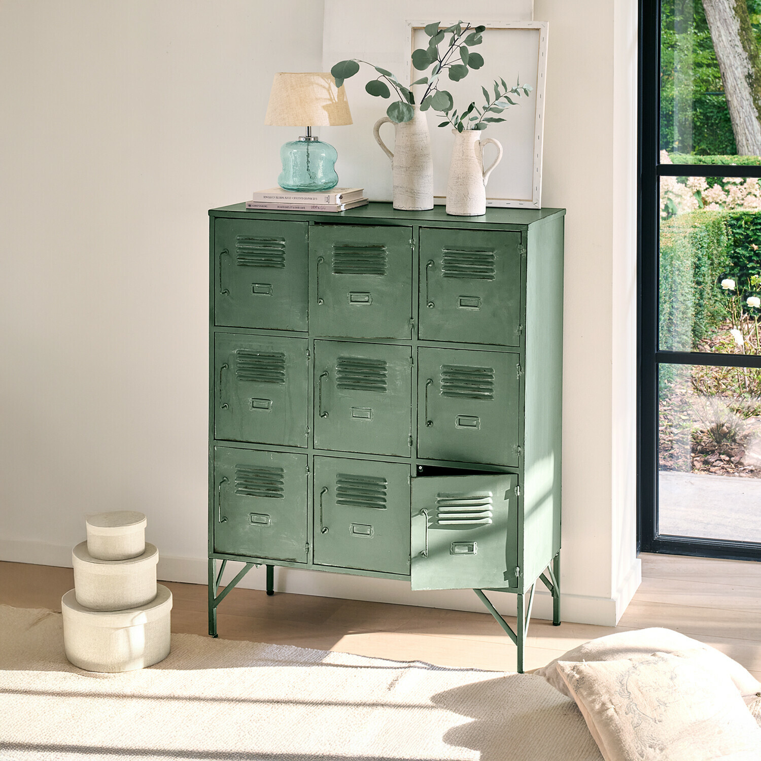 Cómoda Urillac Armario metálico verde con nueve puertas y decoraciones encima en interior luminoso