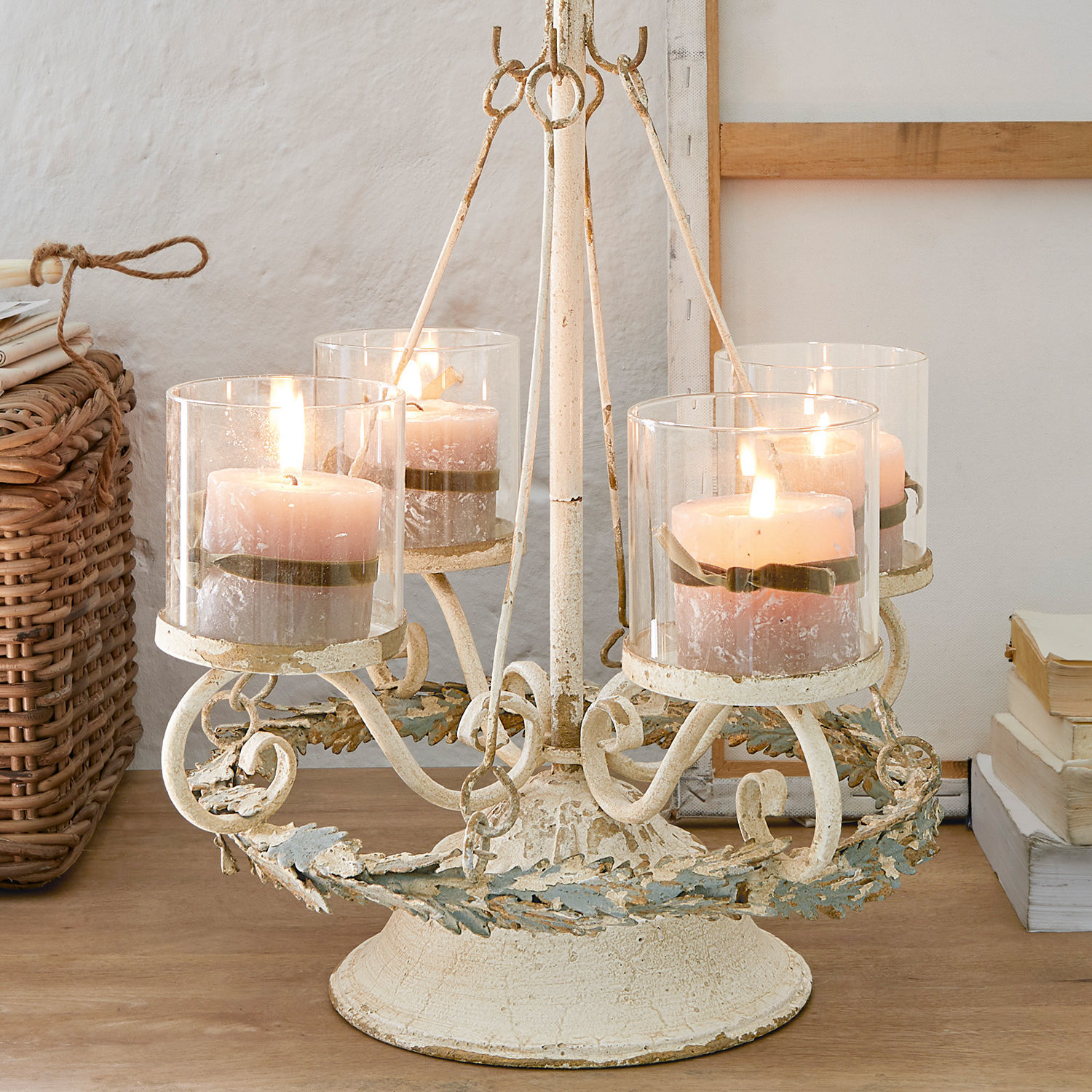 Soporte para corona de Adviento Denders Candelabro de metal con cuatro velas rosas en protectores de vidrio sobre mesa de madera