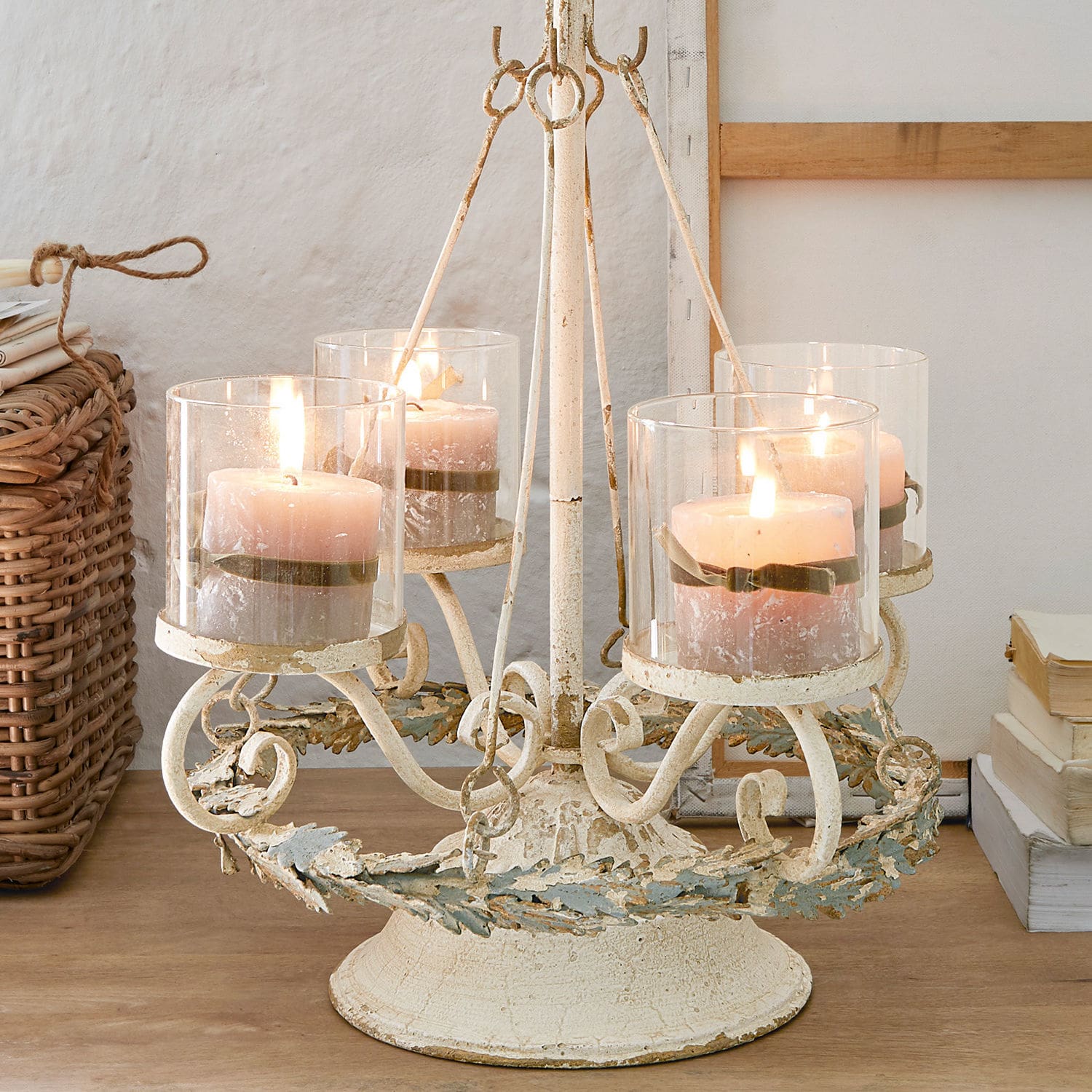 Soporte para corona de Adviento Denders Candelabro de metal con cuatro velas rosas en protectores de vidrio sobre mesa de madera