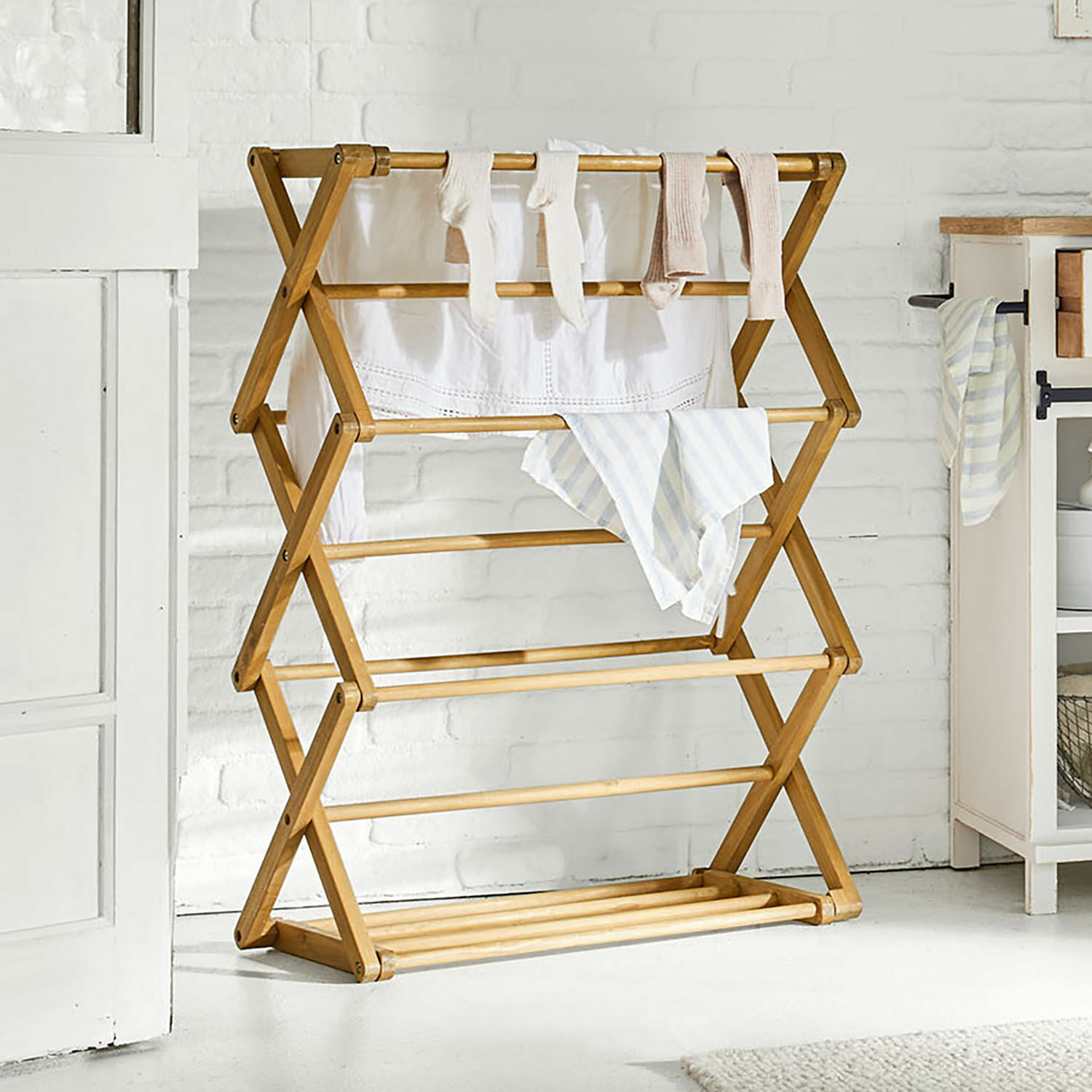 Tendedero Elodielle Tendedero plegable de madera en color natural para uso doméstico en habitación luminosa