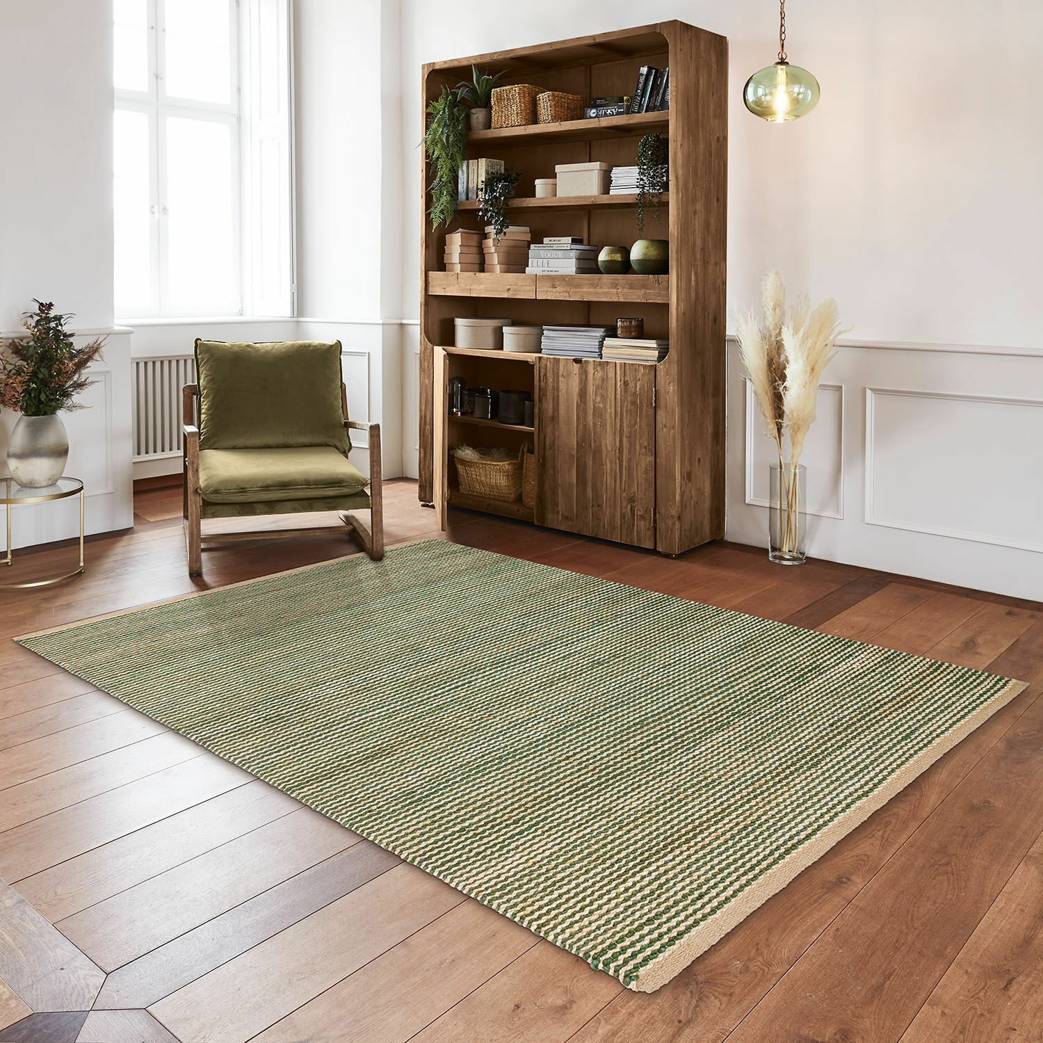 Alfombra de material natural con rayas verde y beige sobre suelo de madera en salón moderno