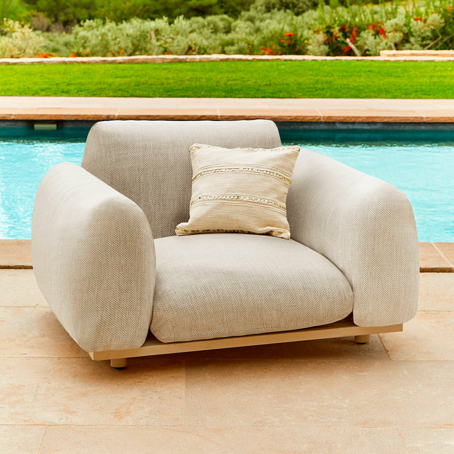 Sillón beige de tela con cojín decorativo, mueble moderno para terraza o jardín